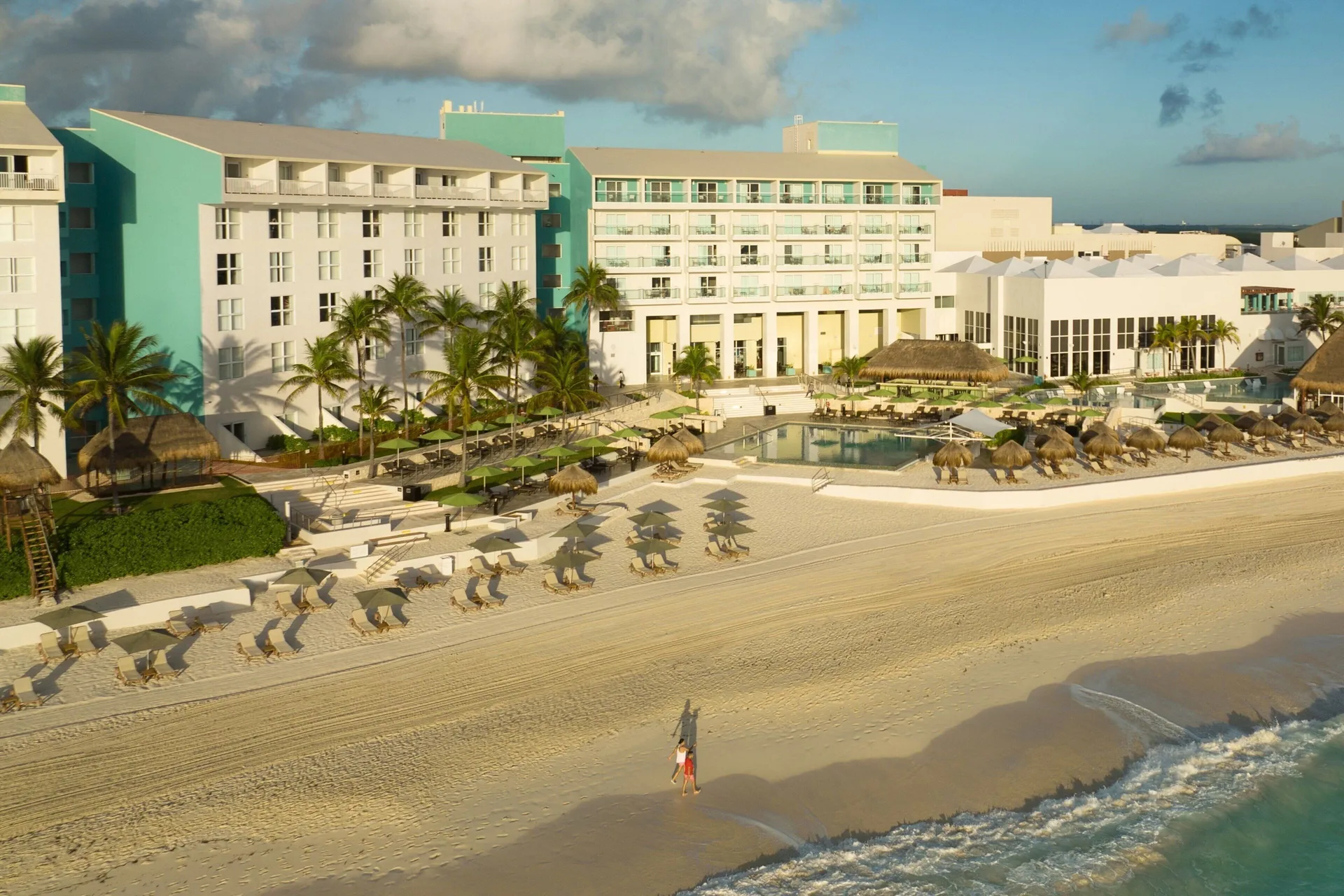 Beachfront resort buildings, pool, palapas, and sand at The Westin Resort & Spa, Cancun.