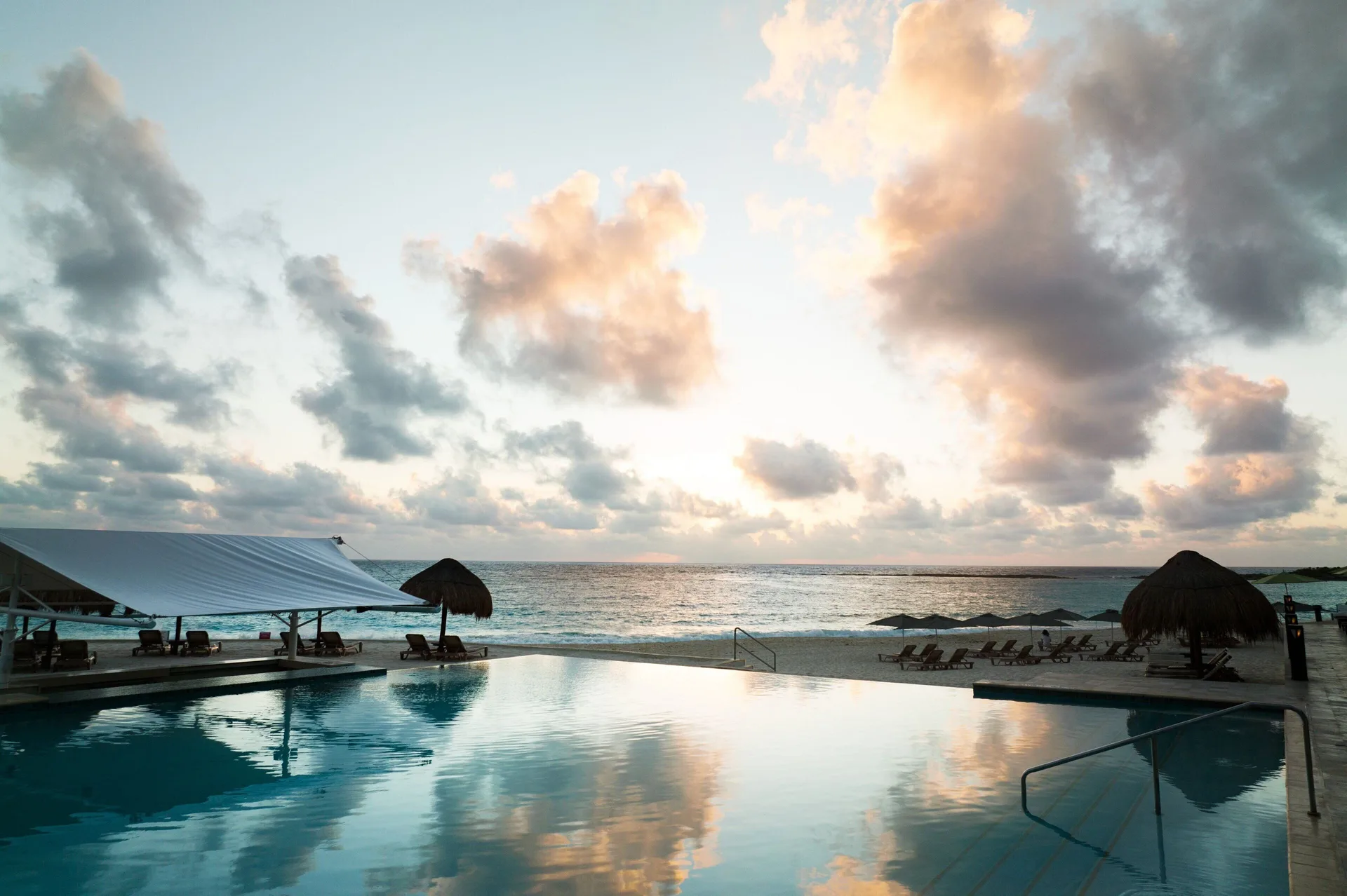 Sunrise over the ocean reflects in the pool at The Westin Resort & Spa, Cancun.