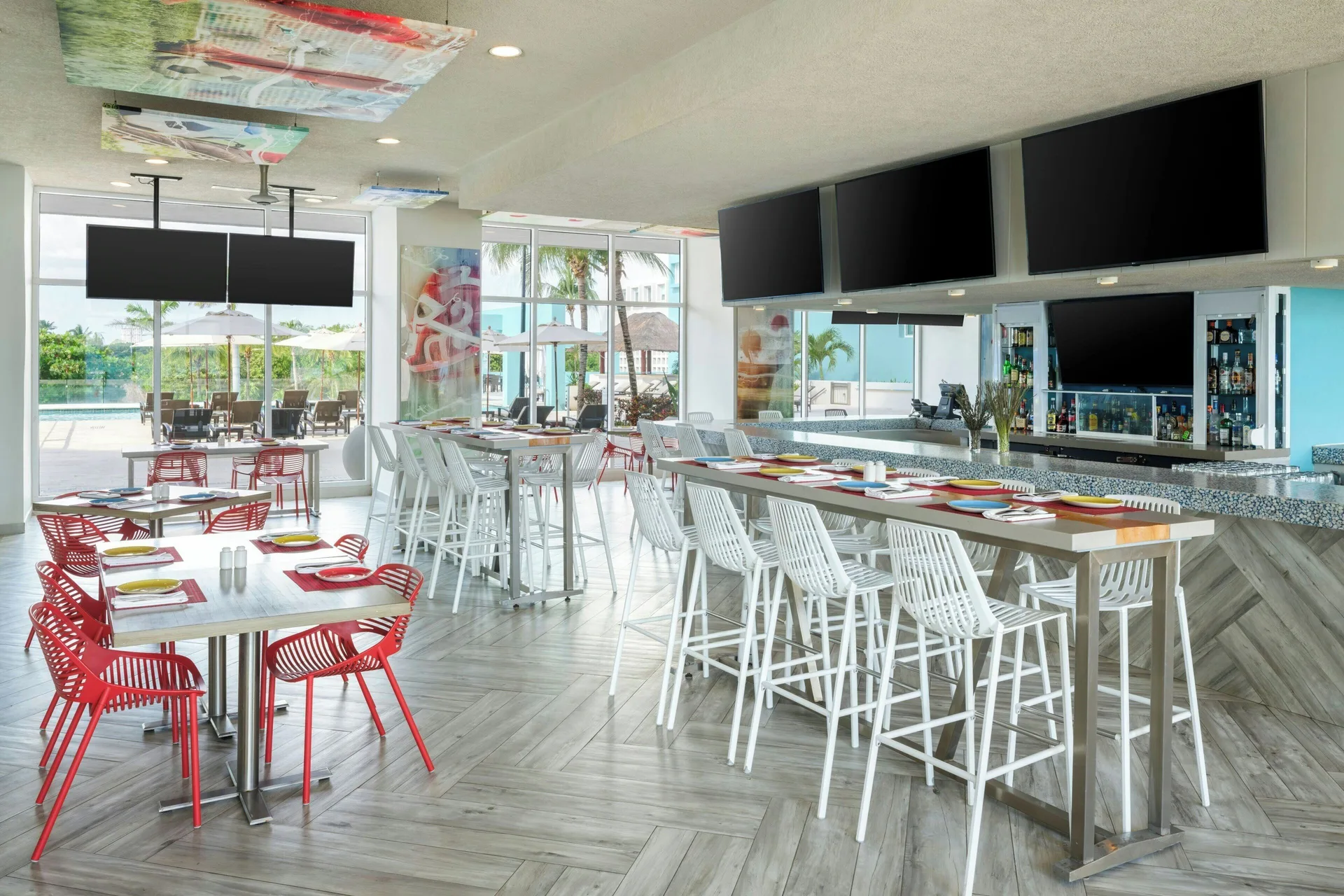 Casual sports bar dining area with red chairs at The Westin Resort & Spa, Cancun.