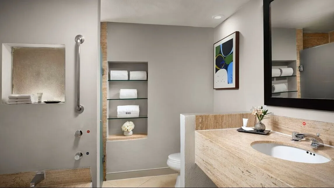 Ocean View room bathroom at The Westin Resort & Spa, Cancun with vanity, shower, toilet, and towel shelves.