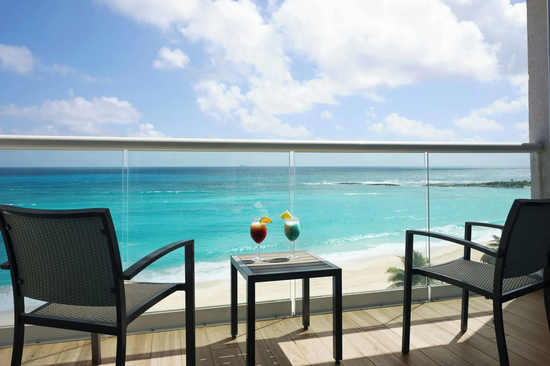 Private ocean-view balcony with chairs and table at The Westin Resort & Spa, Cancun.