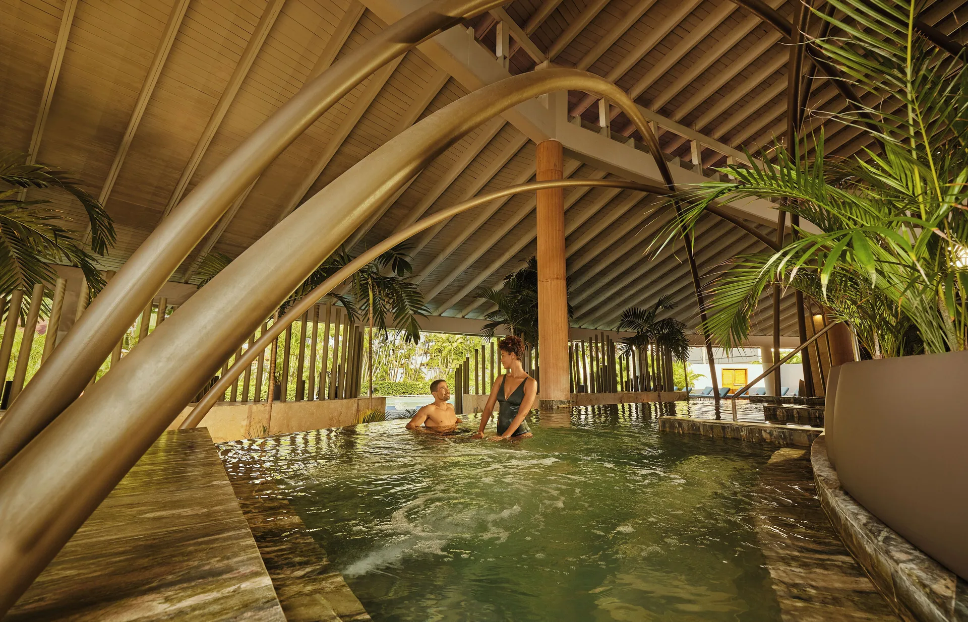 Covered spa pool with two guests under a peaked roof at TRS Turquesa Hotel.