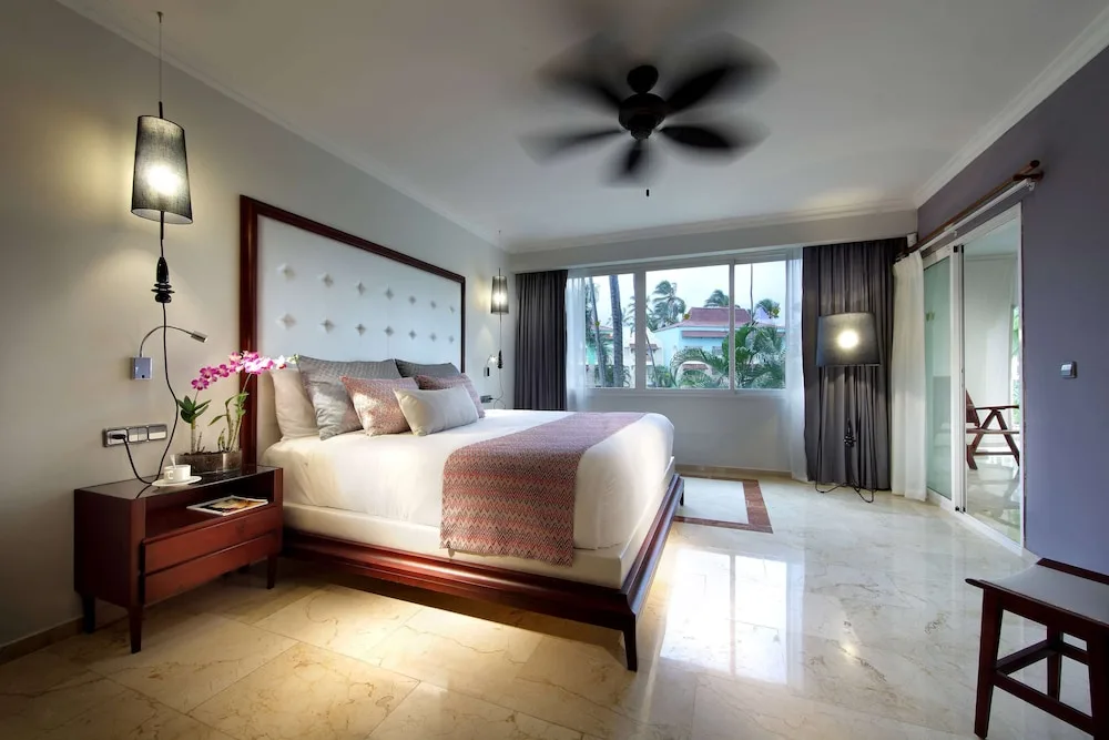 King-bed guest room with balcony doors and garden views at TRS Turquesa Hotel.