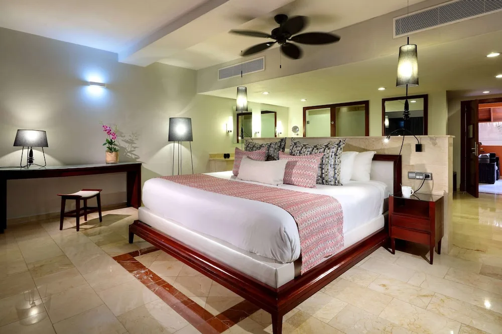 Guest room with a king bed, lamps, and marble floor at TRS Turquesa Hotel.