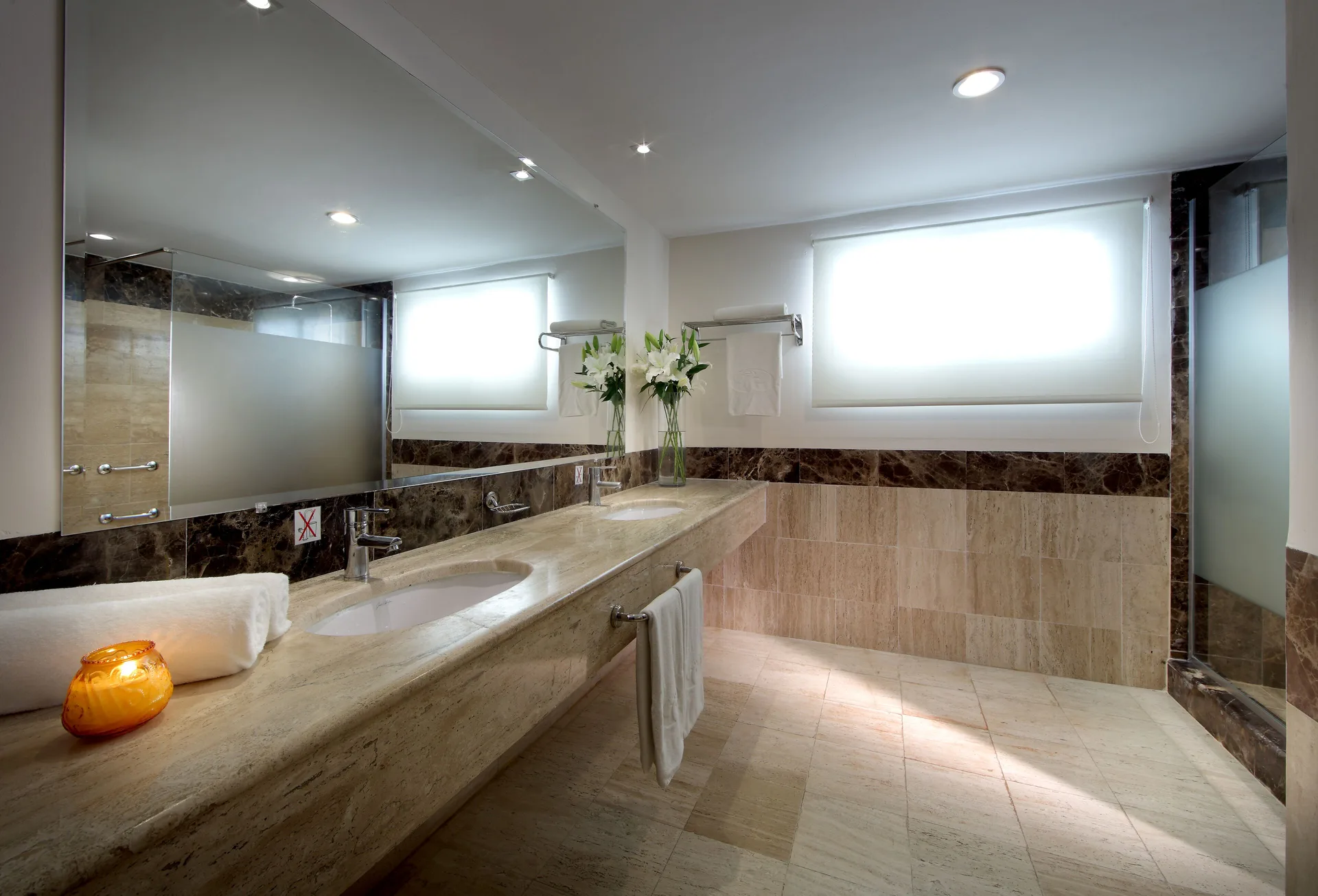 Marble bathroom vanity with frosted-glass shower at TRS Turquesa Hotel.
