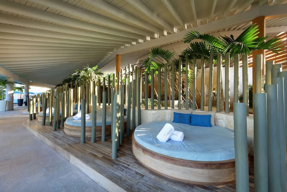 Shaded spa-style daybeds with blue cushions at TRS Turquesa Hotel.