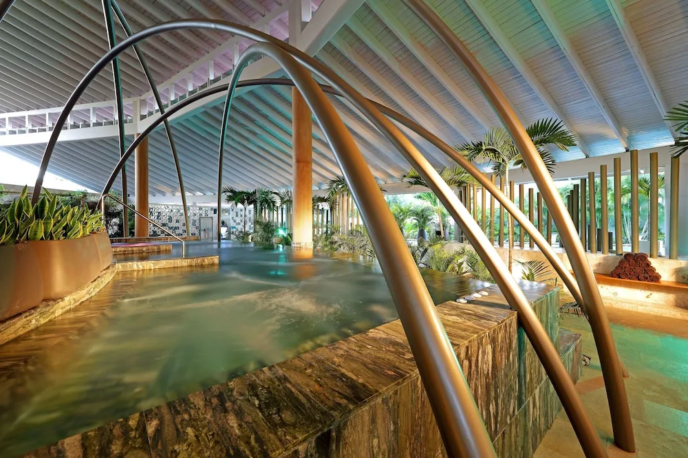 Spa pool with metal arch water features and loungers at TRS Turquesa Hotel.