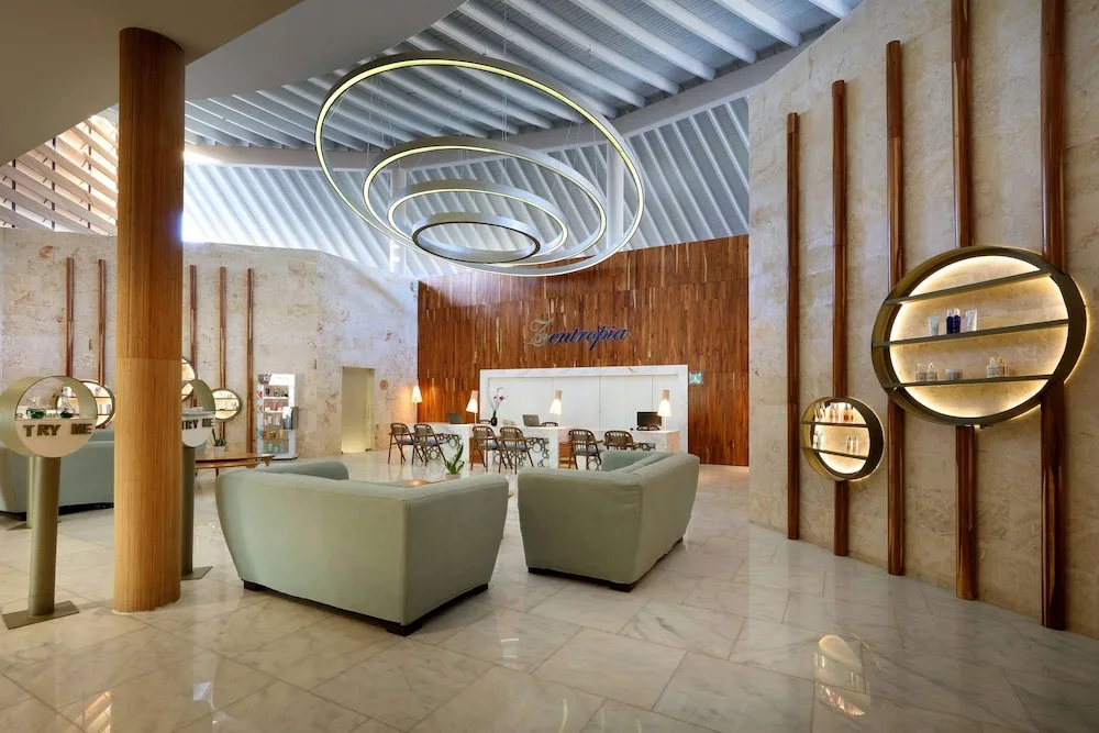 Spa reception lounge with circular lighting and marble floors at TRS Turquesa Hotel.