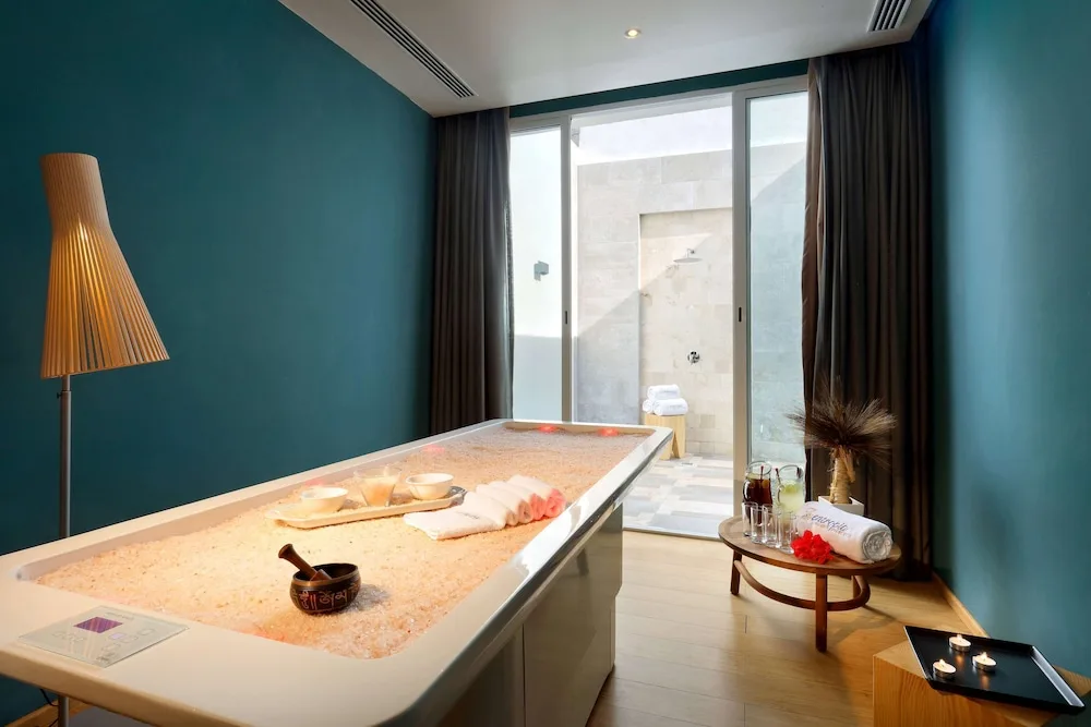 Spa treatment room with a filled soaking tub and candles at TRS Turquesa Hotel.