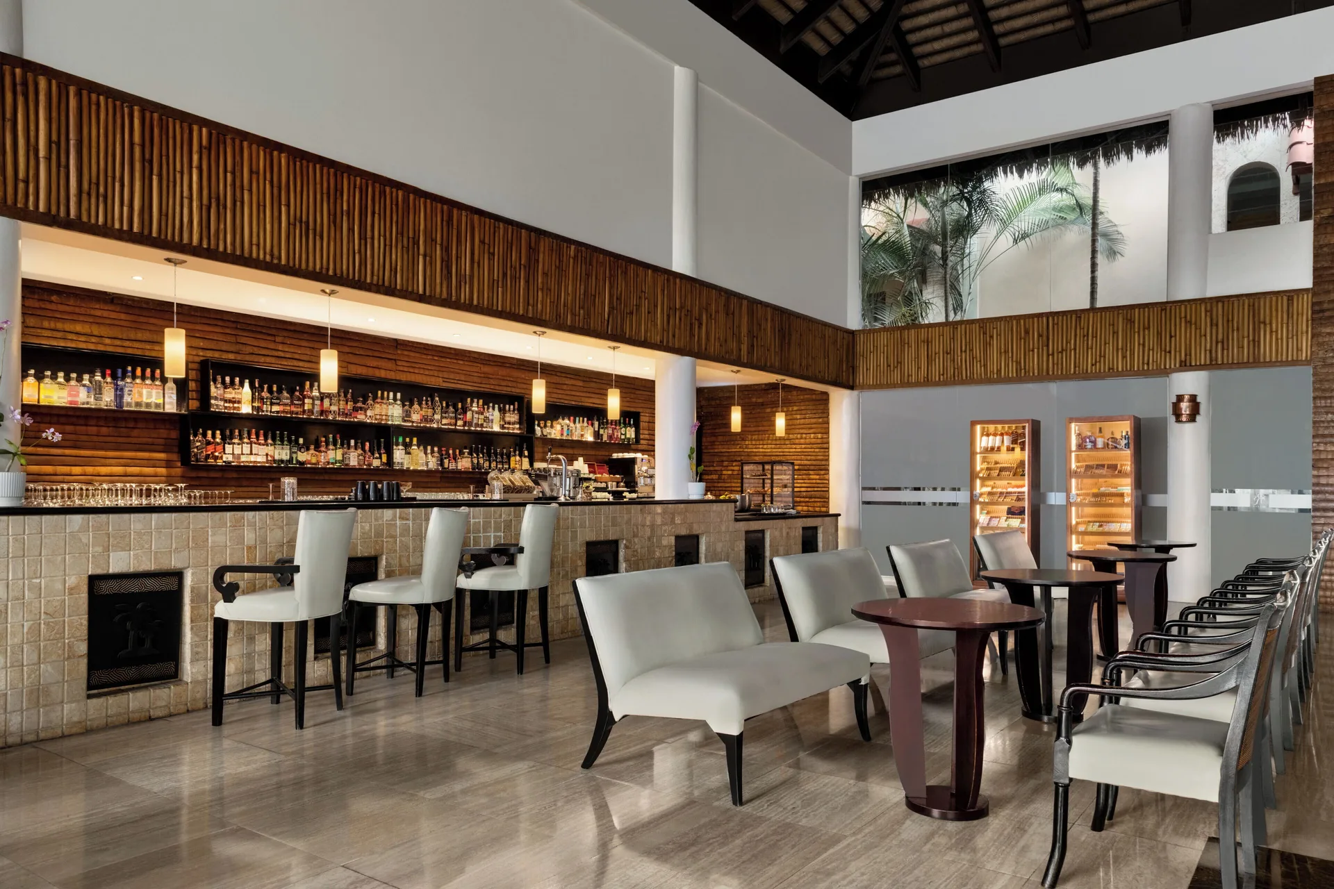 Lobby bar with white seating and bottle shelves at TRS Turquesa Hotel.
