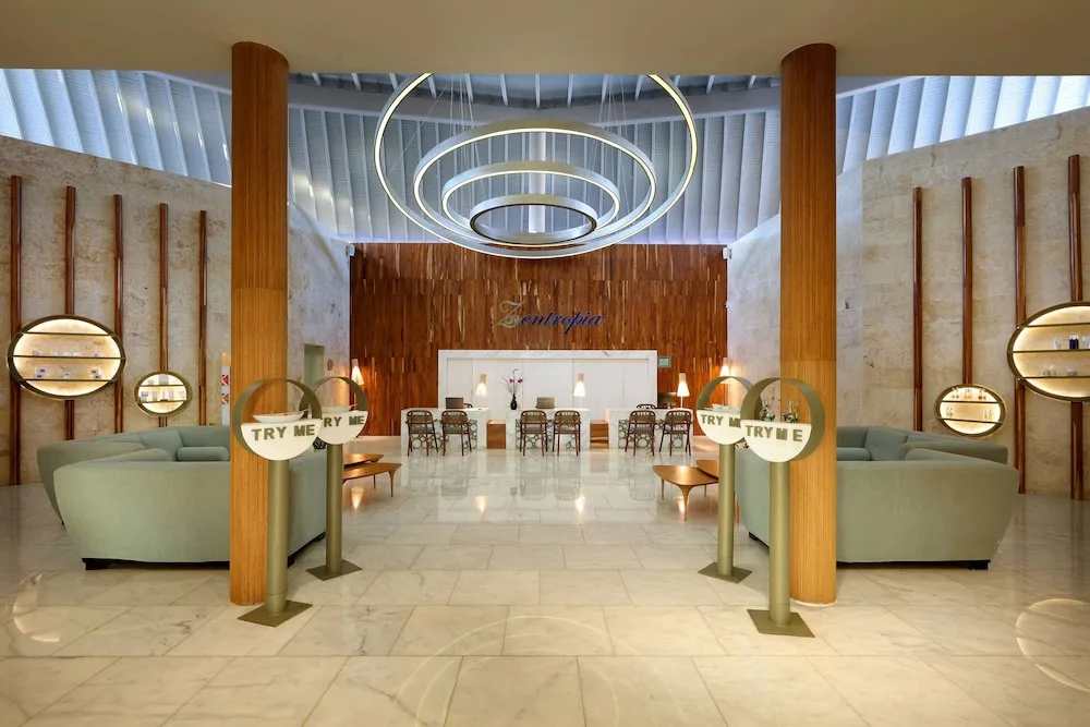Tentazione entrance lounge with sofas and circular ceiling lights at TRS Turquesa Hotel.