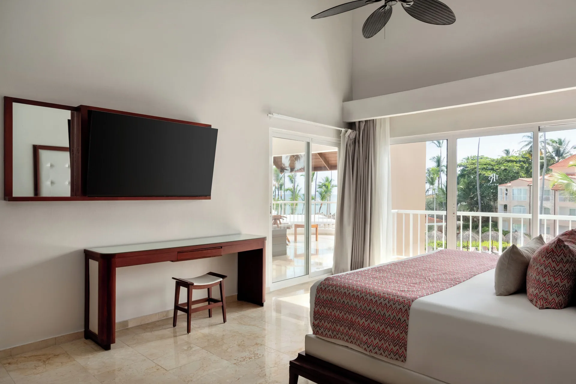 Jacuzzi Terrace Suite Beachside king bed by balcony doors at TRS Turquesa Hotel.