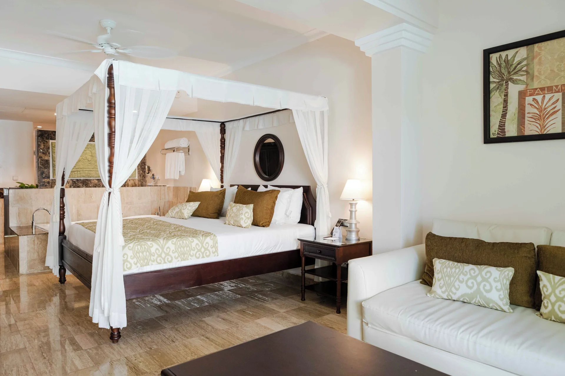 Junior Suite Garden Pool View bedroom with canopy bed and sofa at TRS Turquesa Hotel.