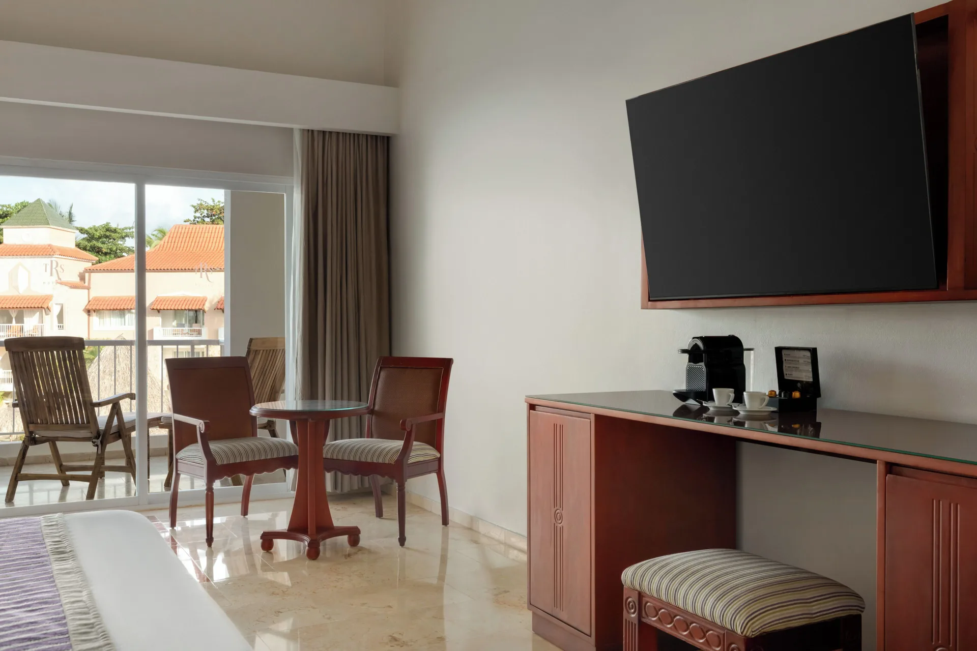 Junior Suite Poolside room with TV, desk, seating, and balcony at TRS Turquesa Hotel.