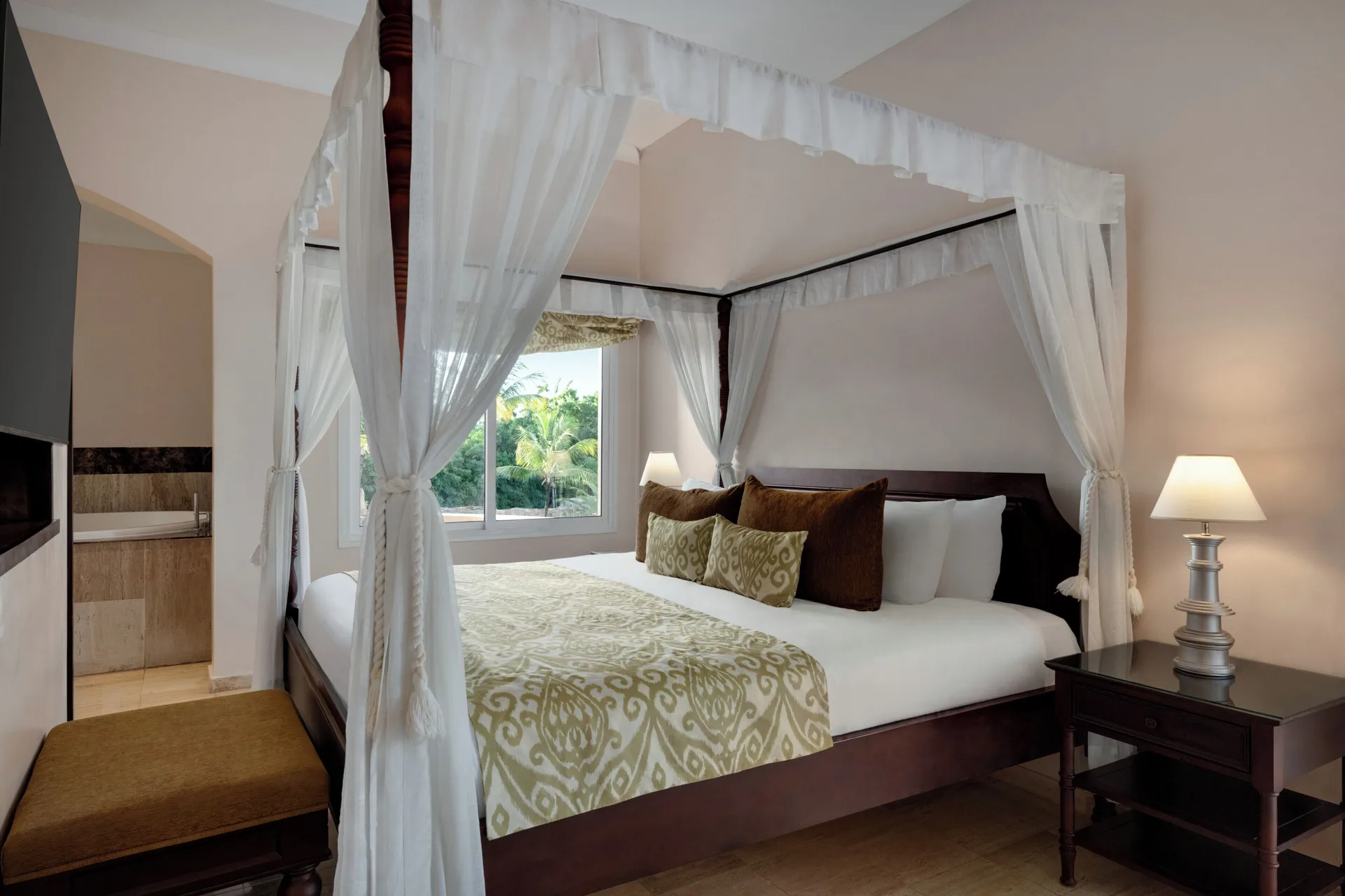 Romance Suite Poolside bed with sheer canopy and window at TRS Turquesa Hotel.