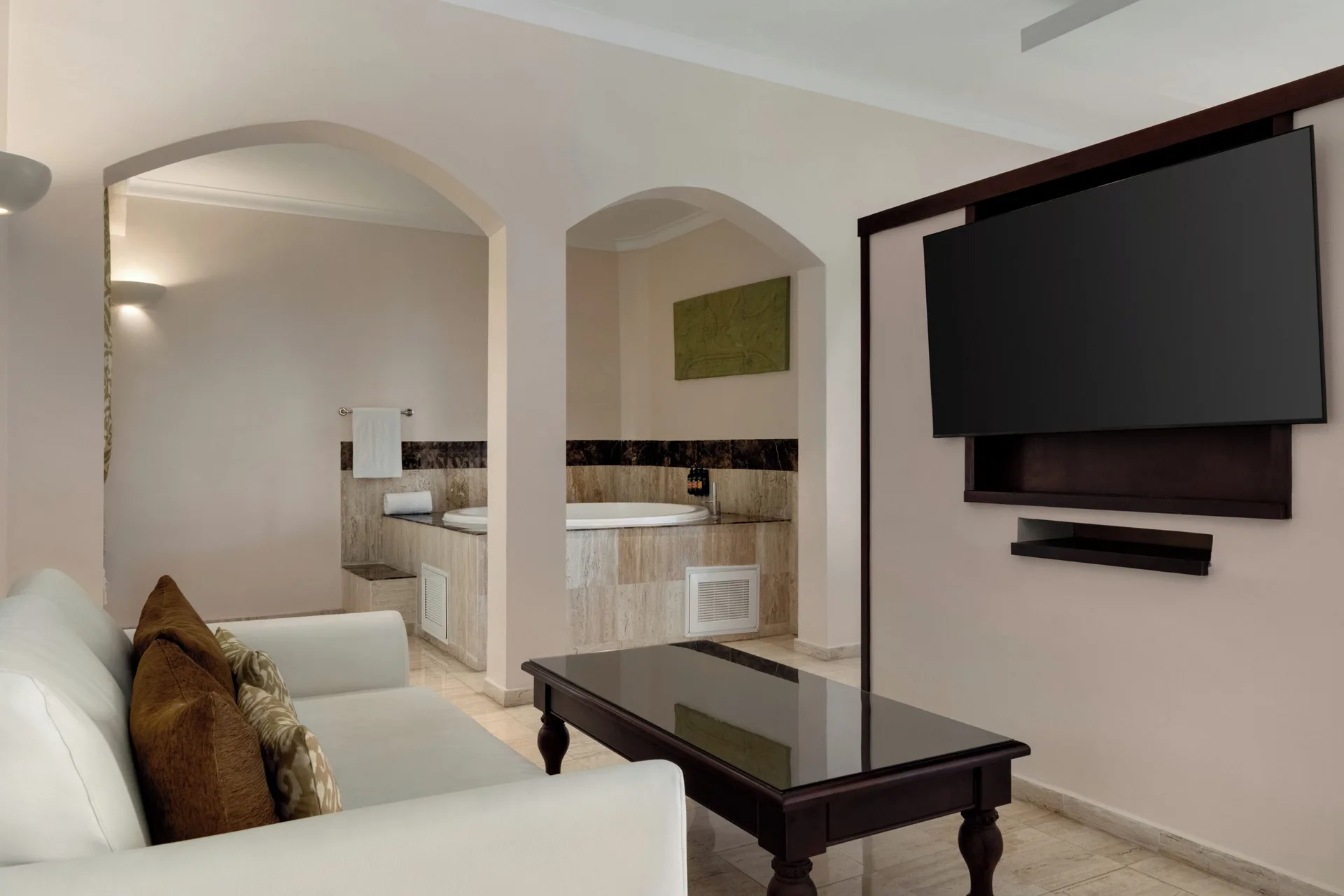 Romance Suite Poolside living area with sofa, TV and tub at TRS Turquesa Hotel.