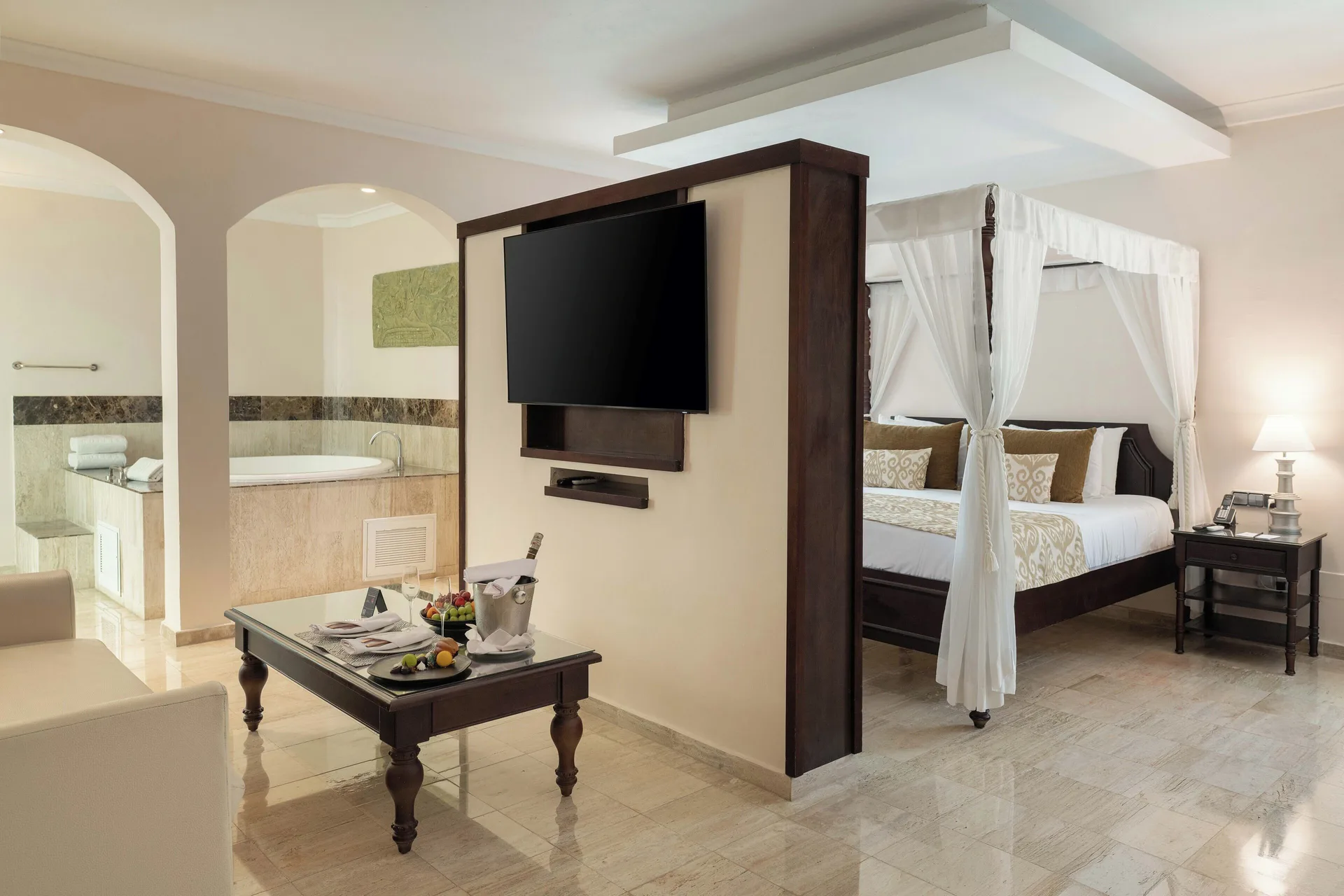 Romance Suite Swim Up suite with canopy bed, TV, and tub at TRS Turquesa Hotel.