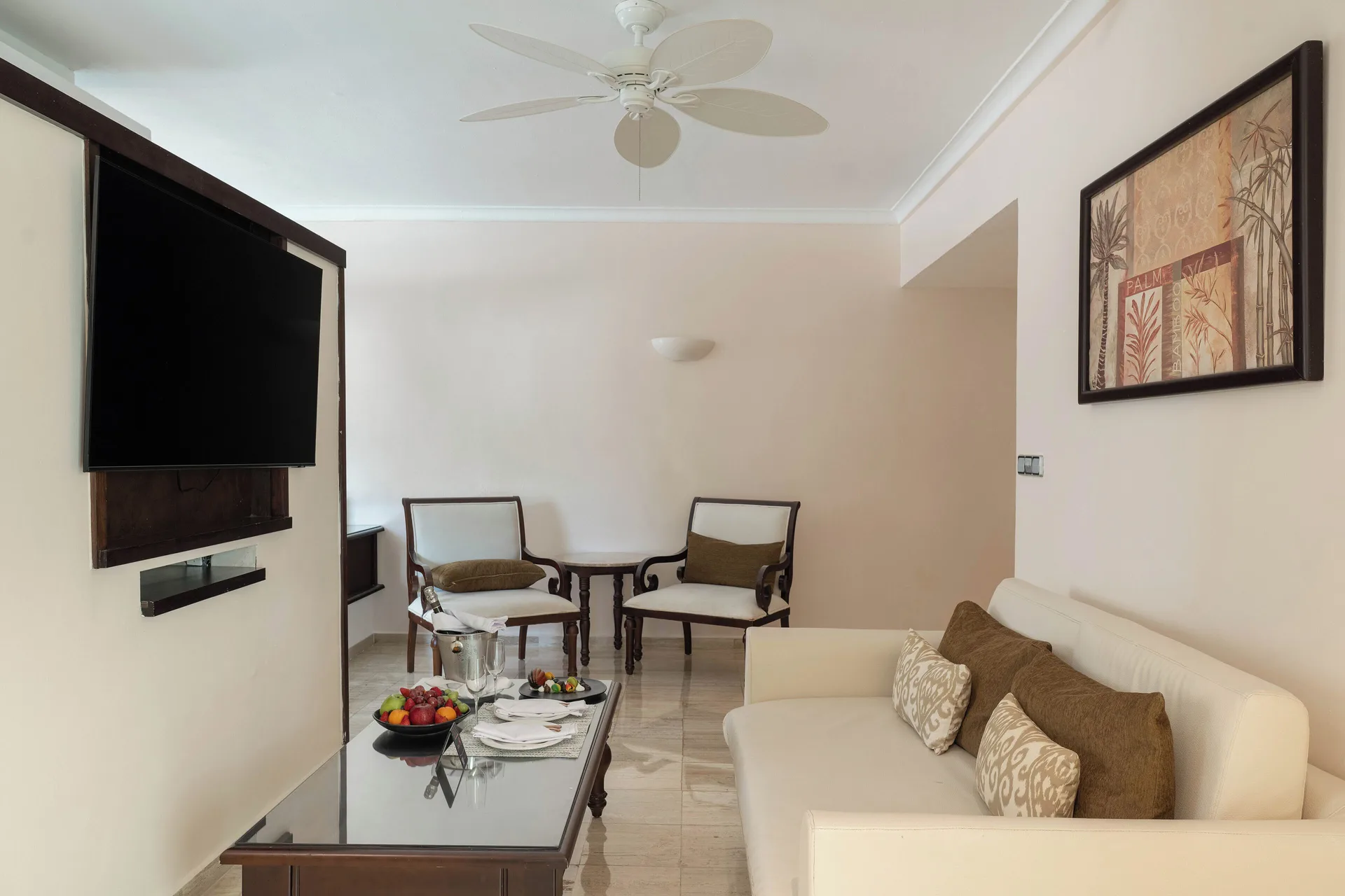 Romance Suite Swim Up living room with sofa and TV at TRS Turquesa Hotel.
