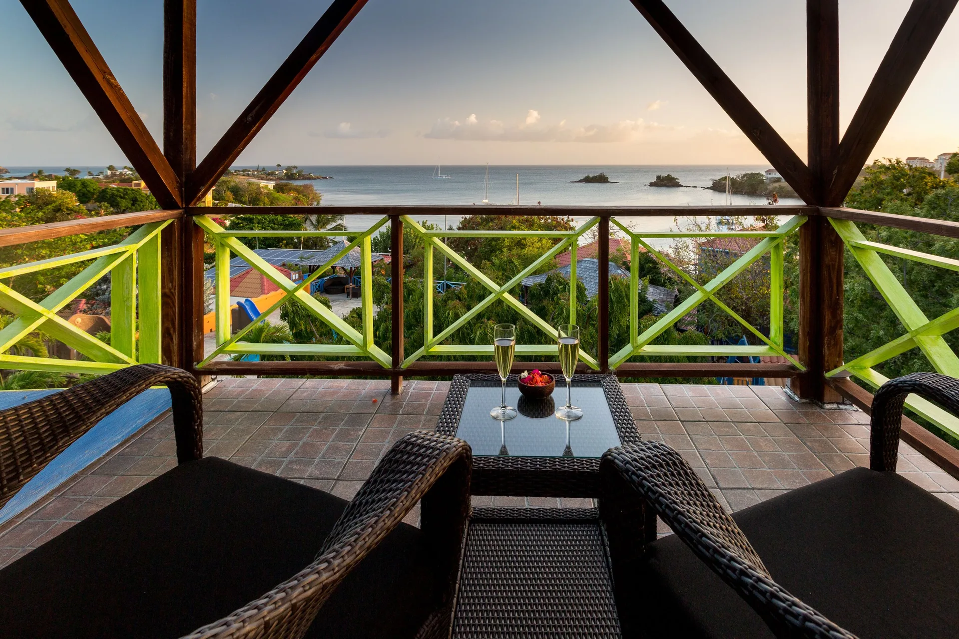 Tower Suite balcony with wicker seating and bay view at True Blue Bay Resort.