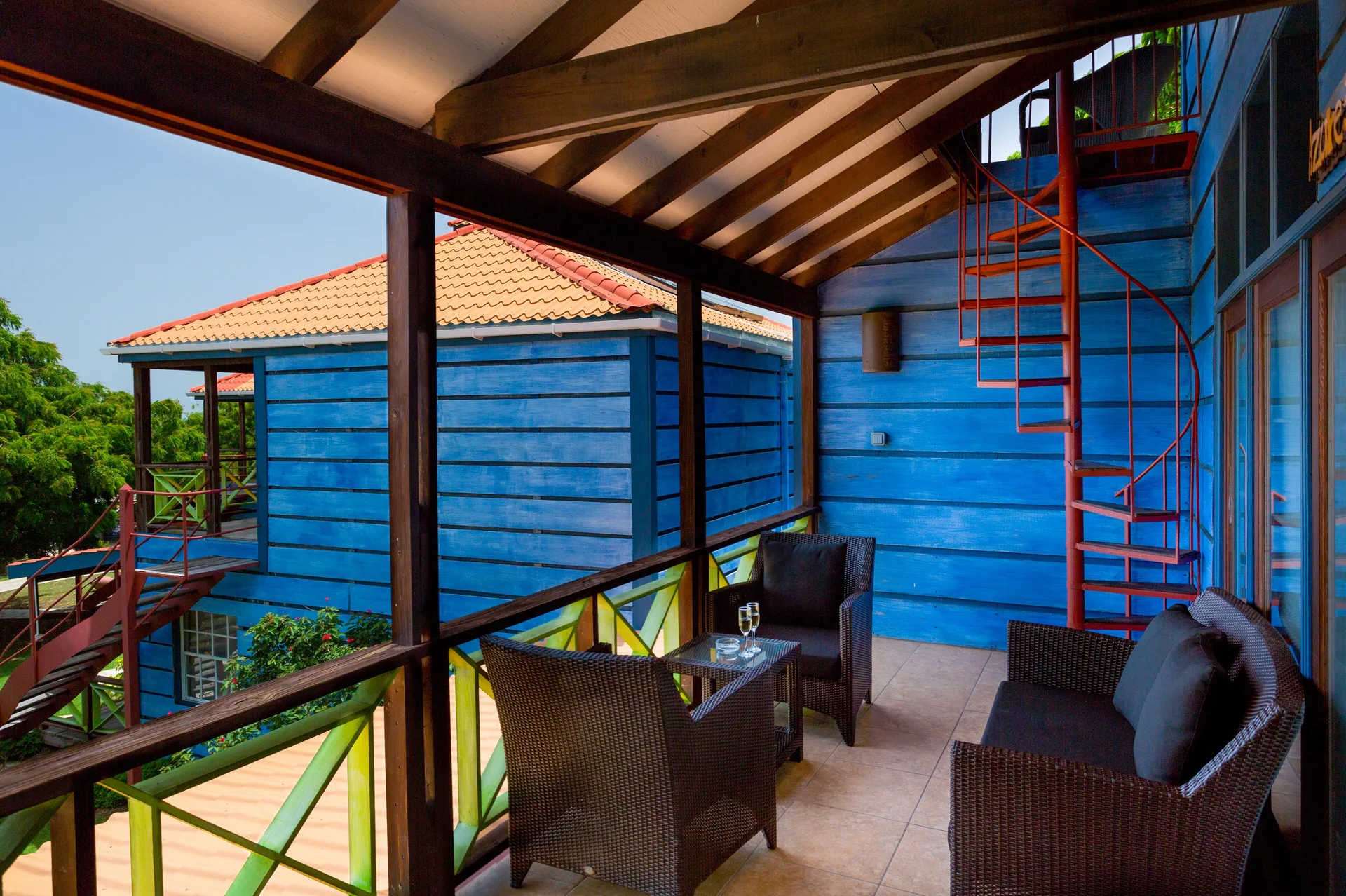 Tower Suite covered balcony with wicker seating at True Blue Bay Resort.