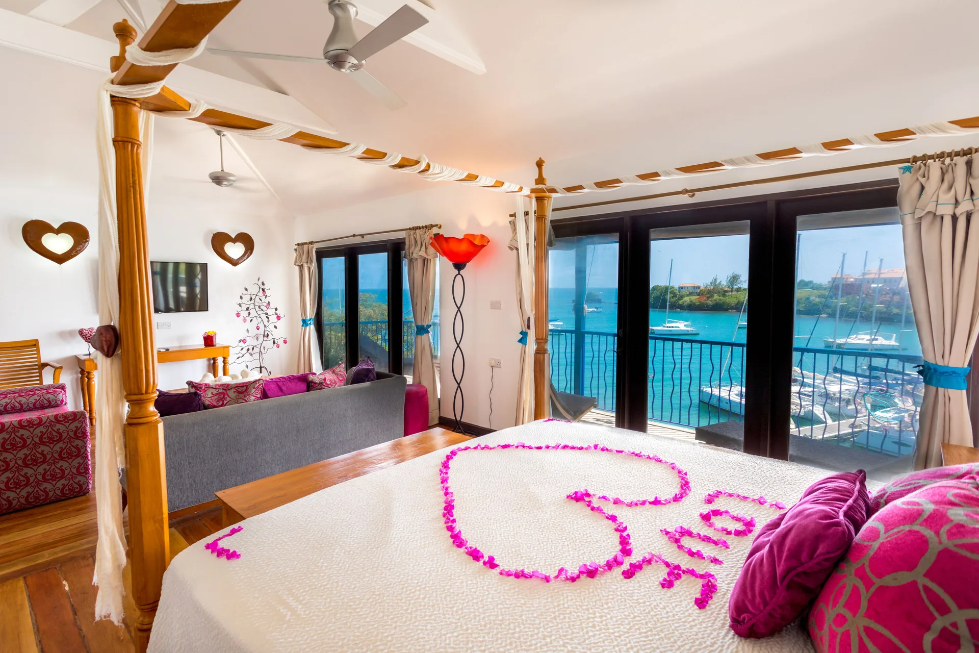 Tower Suite bed with marina-facing balcony doors at True Blue Bay Resort.