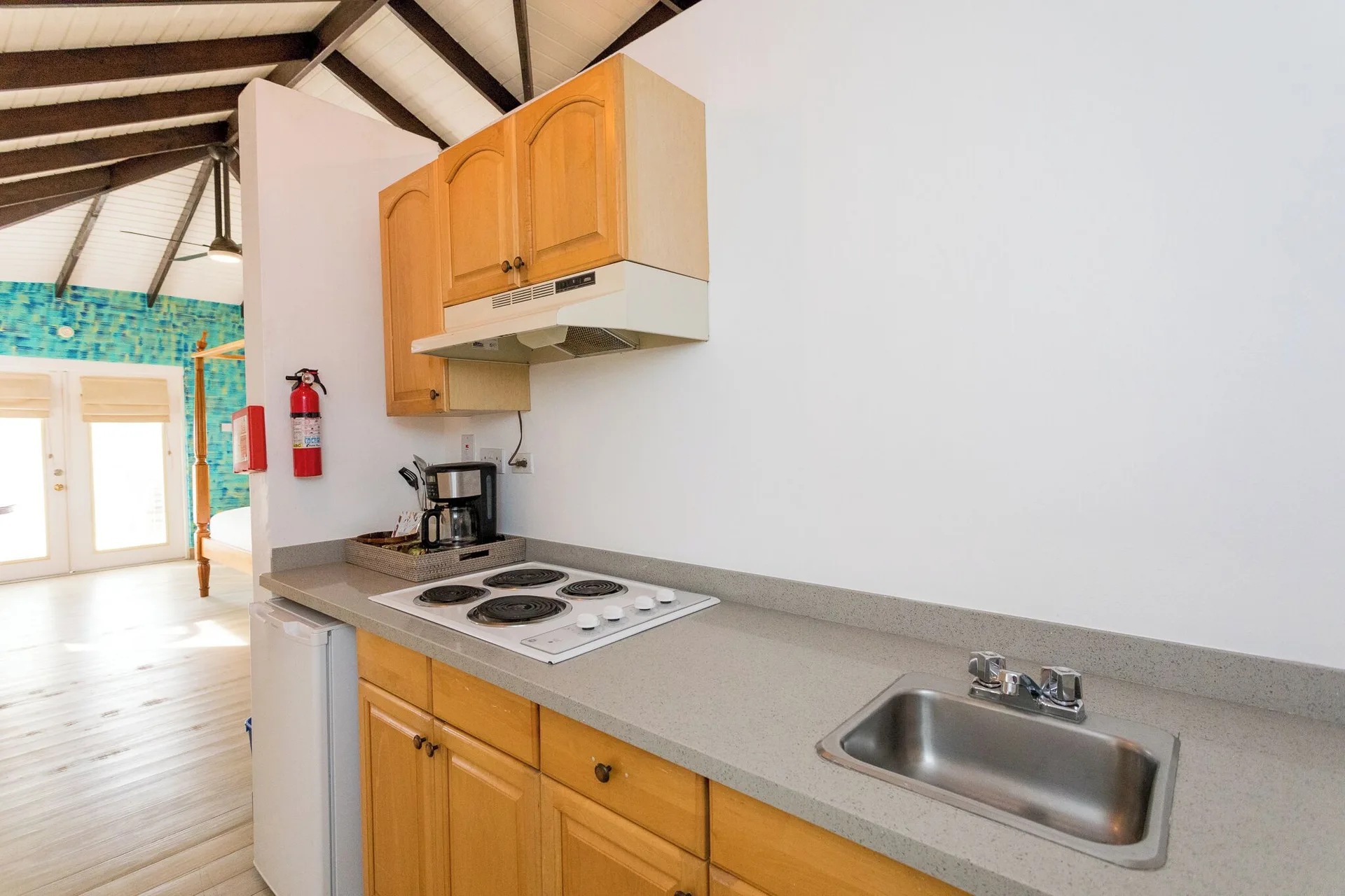 True Blue Bay Resort kitchenette at True Blue Bay Resort with cooktop, sink, fridge, and coffee maker.