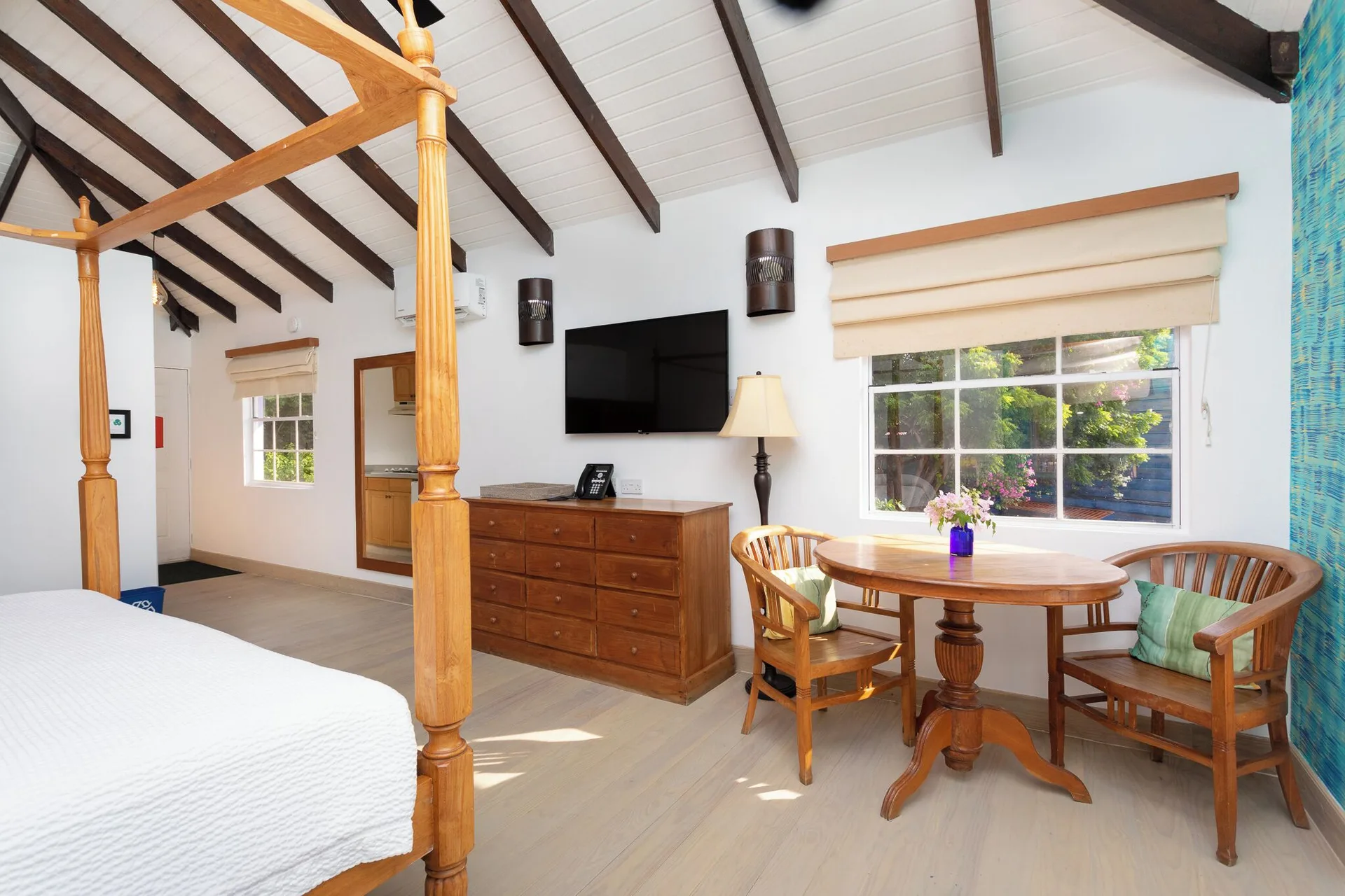 True Blue Bay Resort at True Blue Bay Resort with bed, dresser, TV, and round table by the window.