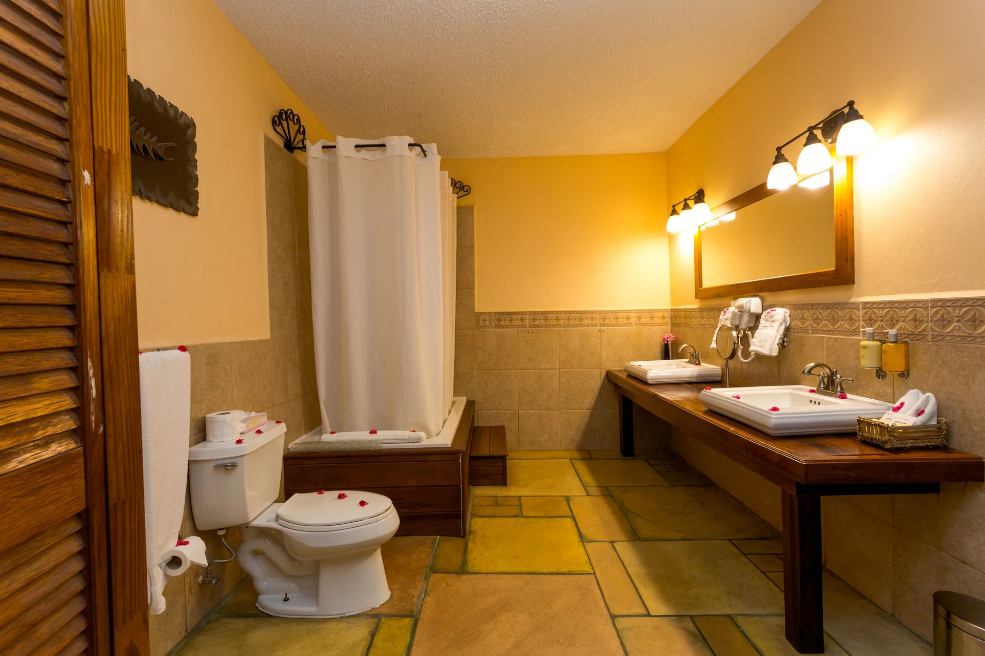 True Blue Bay Resort bathroom at True Blue Bay Resort with double sinks, shower curtain, and toilet.