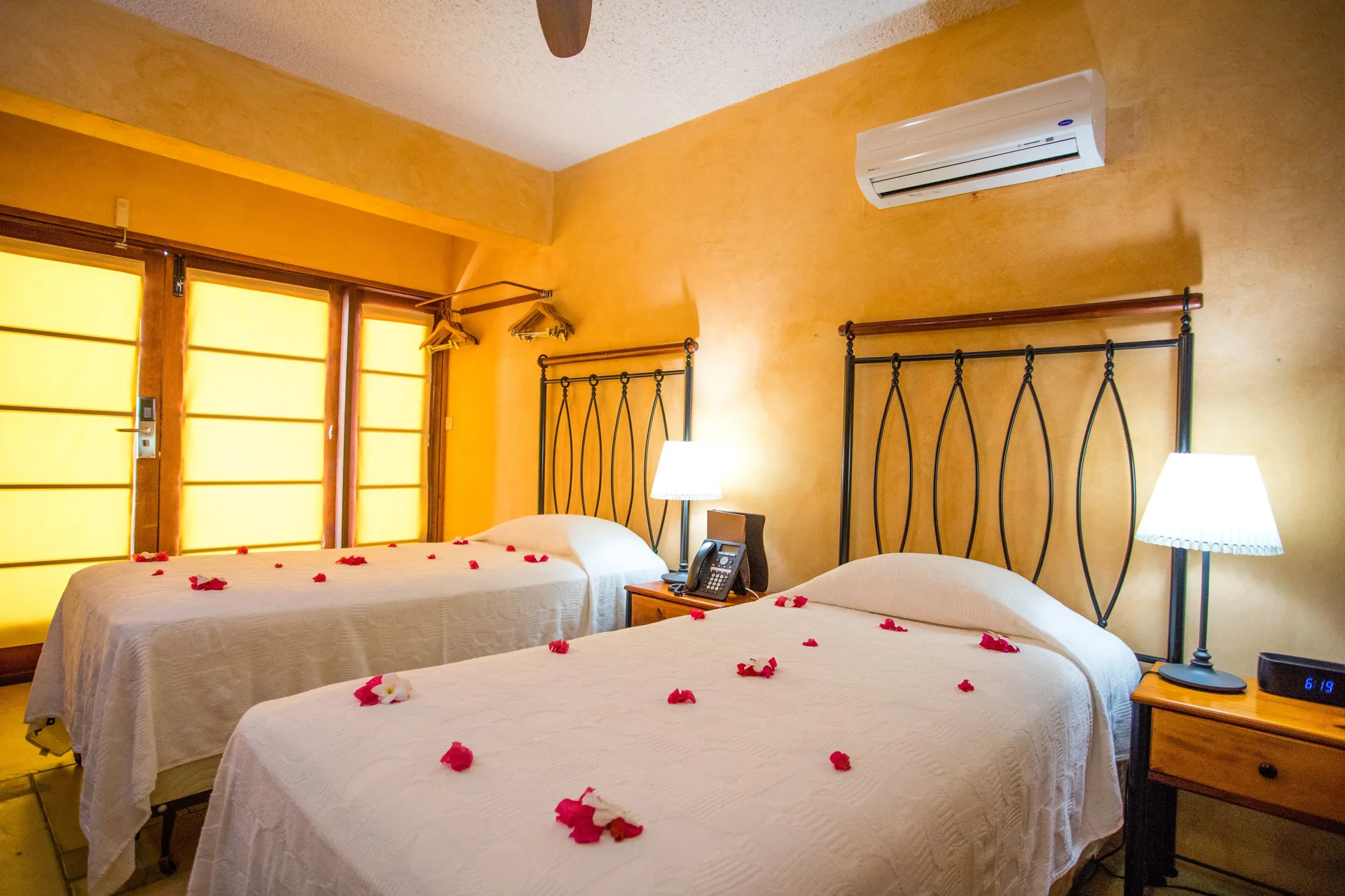 True Blue Bay Resort bedroom with two beds and flower petals at True Blue Bay Resort.