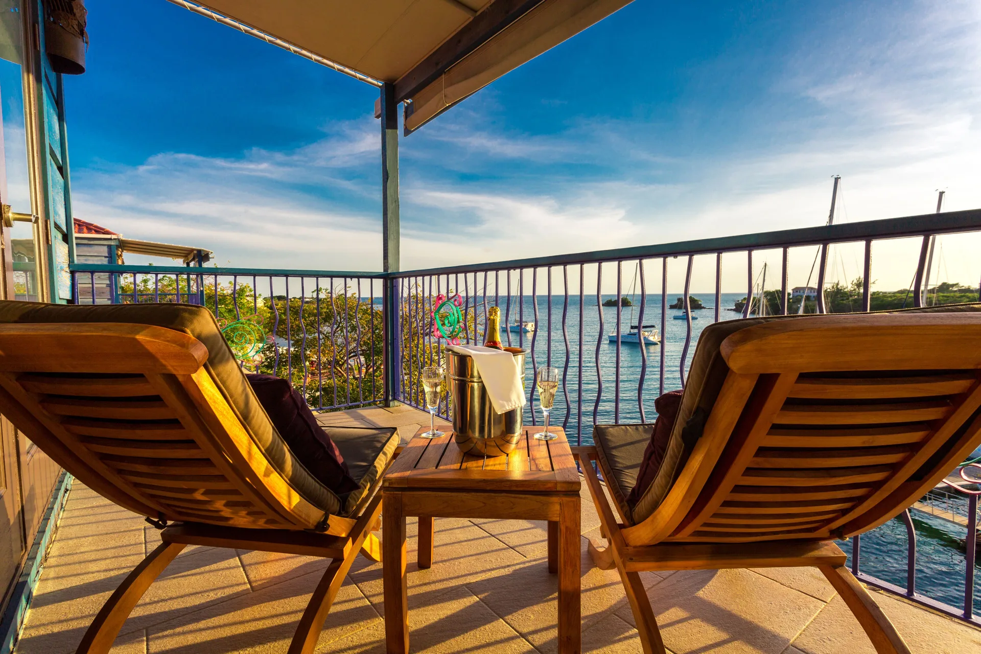 Waterfront Suite balcony with lounge chairs and bay view at True Blue Bay Resort.