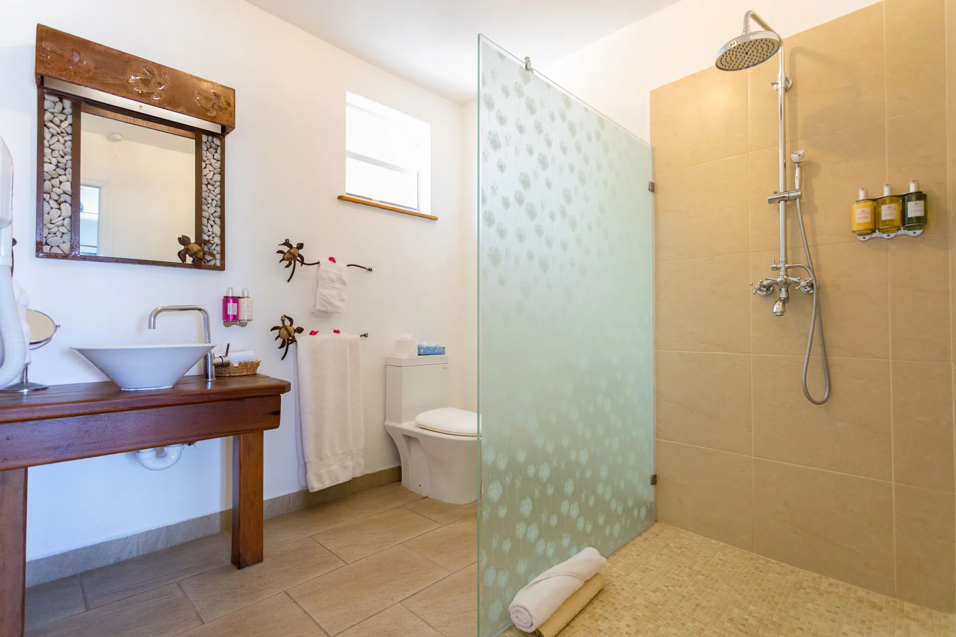 Waterfront Suite bathroom with glass shower at True Blue Bay Resort.