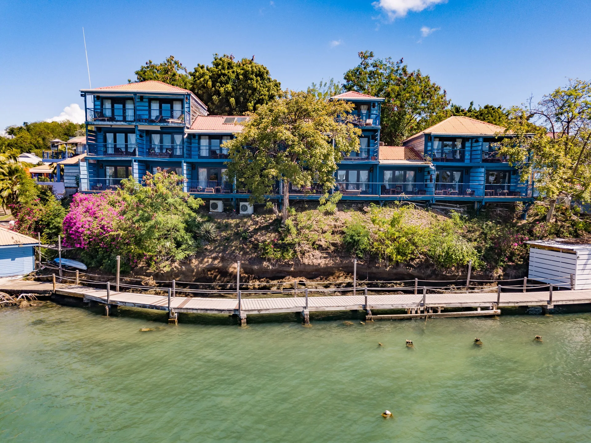 Blue waterfront suite buildings beside the bay at True Blue Bay Resort.