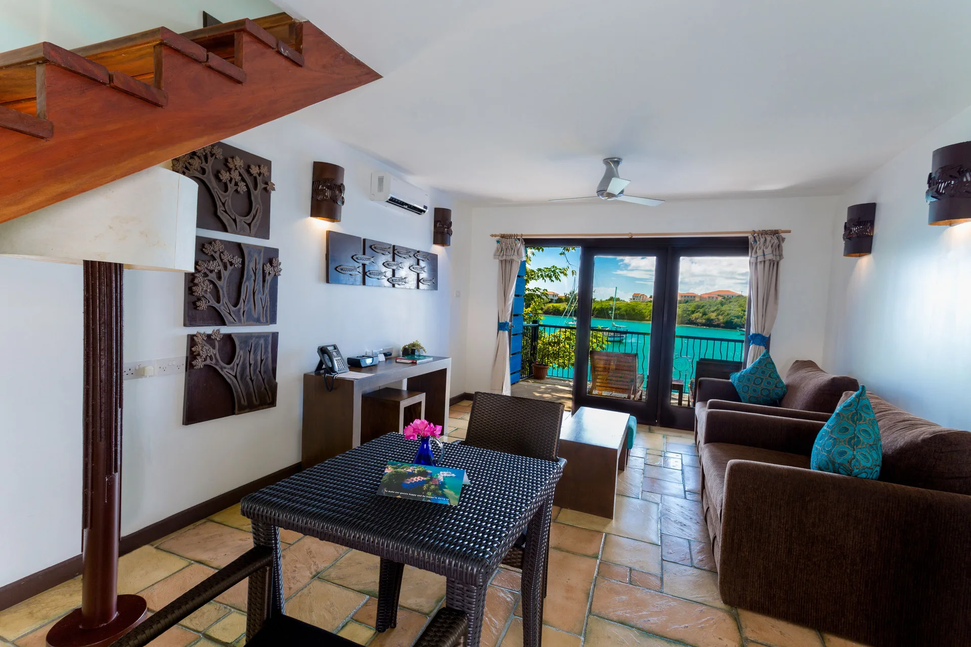 Waterfront Suite living area with balcony view at True Blue Bay Resort.
