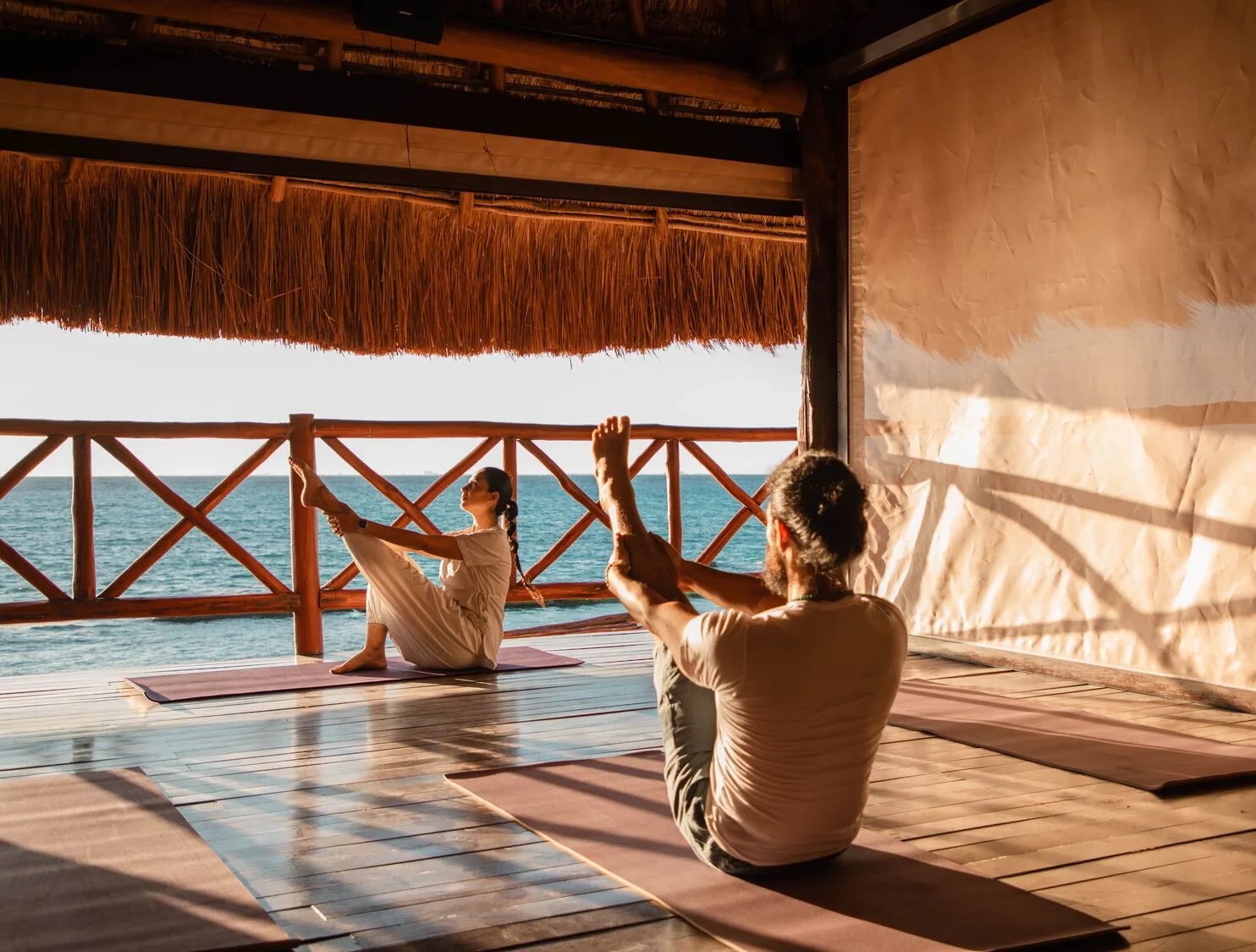 Oceanfront yoga class on a thatched deck at Viceroy Riviera Maya.