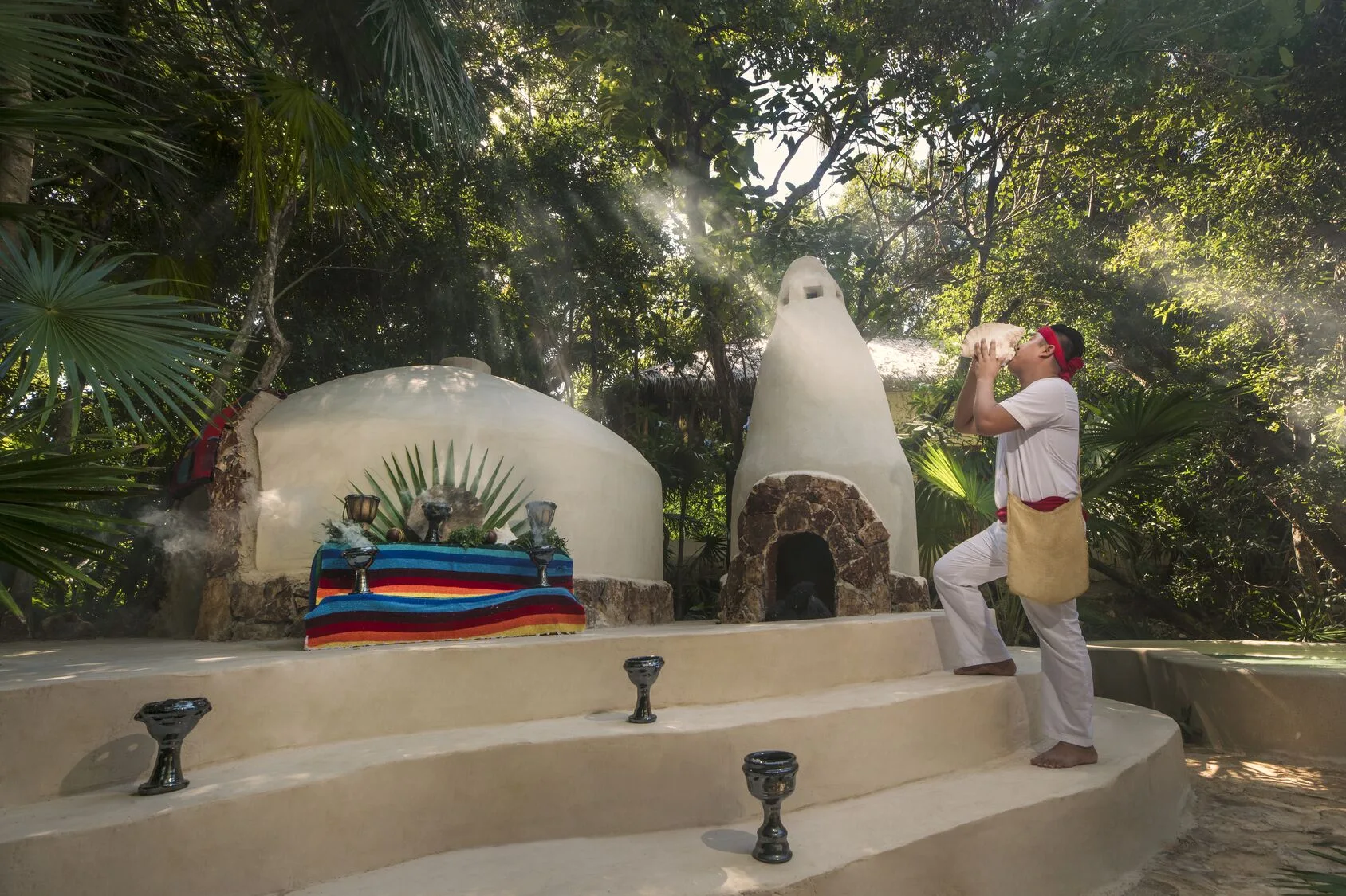 Ceremonial temazcal setting with a staff member in the jungle at Viceroy Riviera Maya.