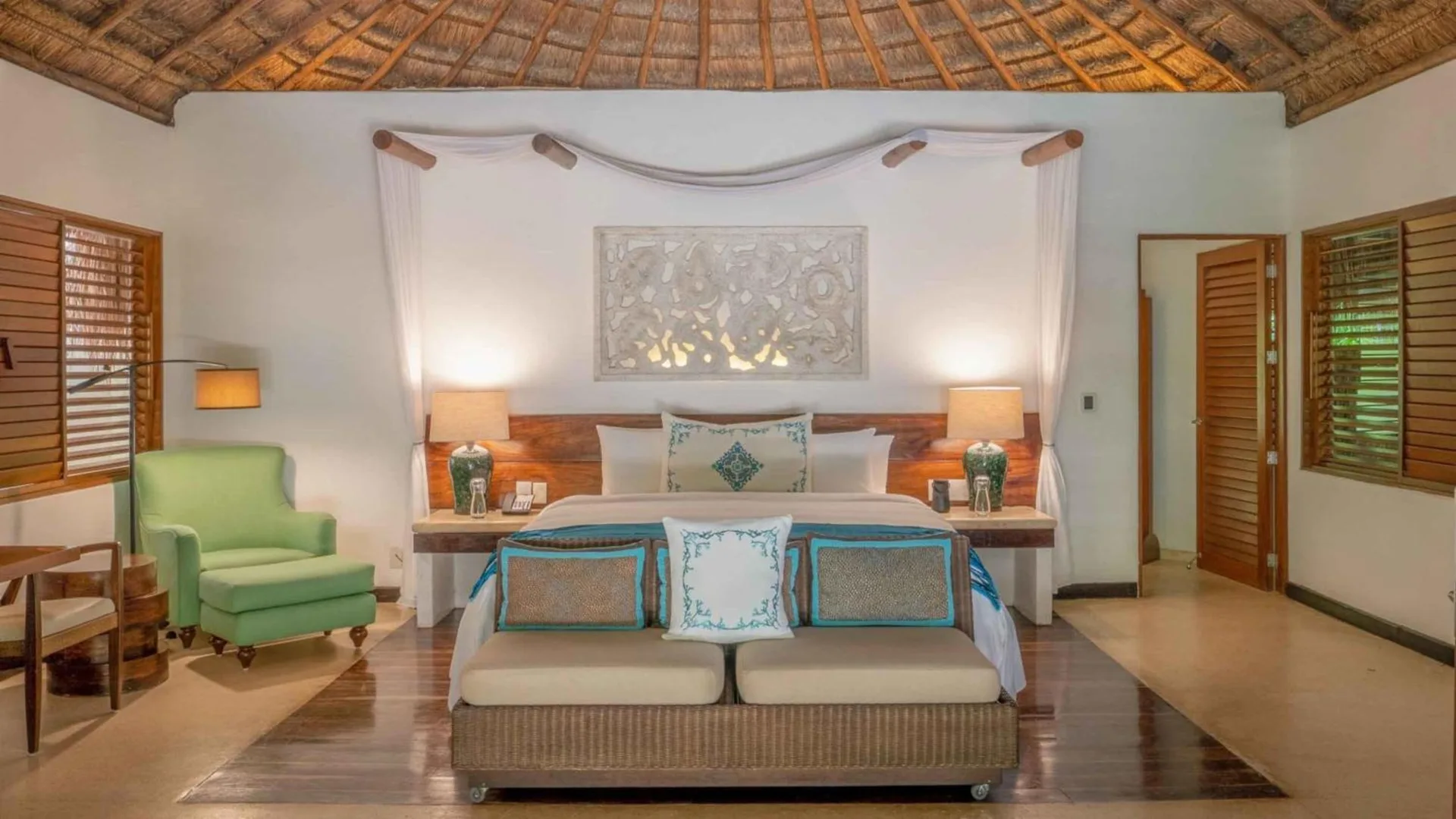 Luxury villa bedroom with king bed and thatched ceiling at Viceroy Riviera Maya.
