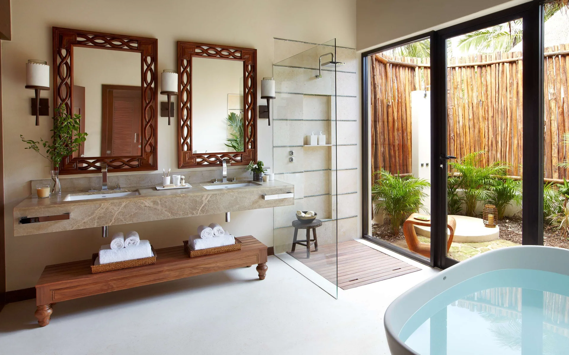 Premium Villa bathroom with double vanity, glass shower, tub, and garden view at Viceroy Riviera Maya.