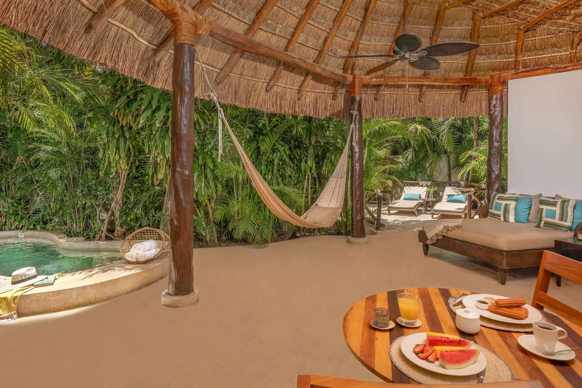 Royal Villa covered deck at Viceroy Riviera Maya with hammock, breakfast table, and plunge pool.