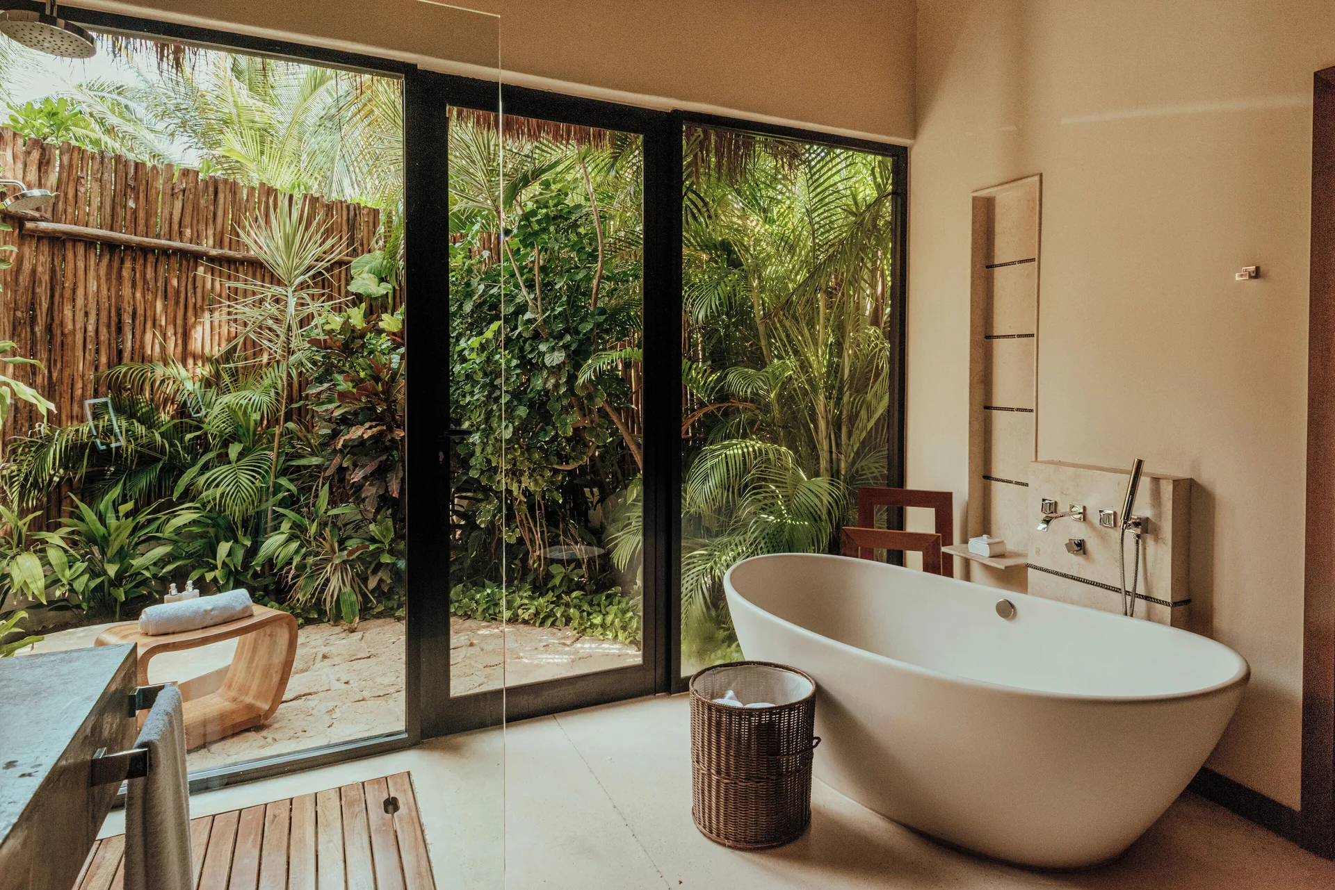 Villa bathroom with freestanding tub and garden view at Viceroy Riviera Maya.