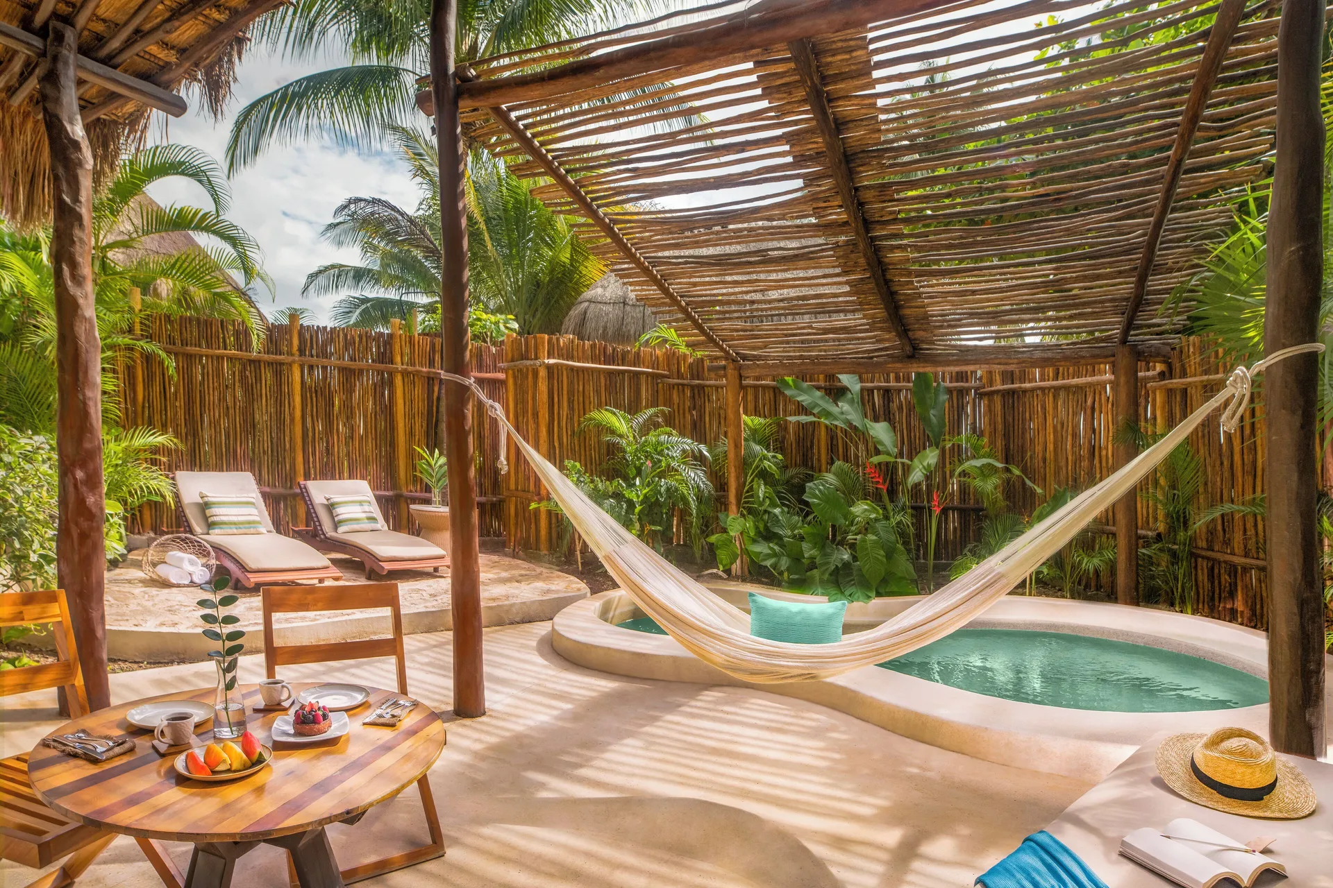 Private villa deck with hammock, plunge pool, loungers, and breakfast at Viceroy Riviera Maya.