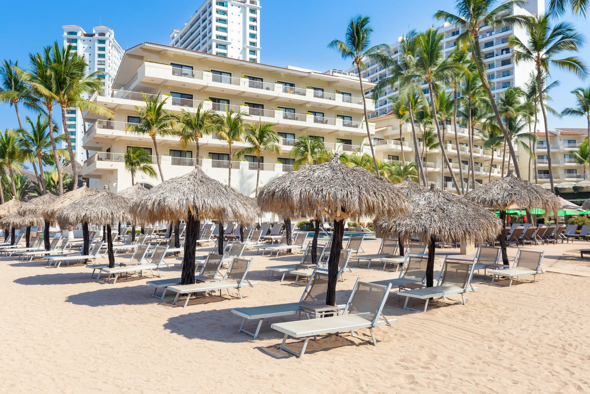 Beach loungers and thatched palapas at Villa del Palmar Beach Resort and Spa, Puerto Vallarta.