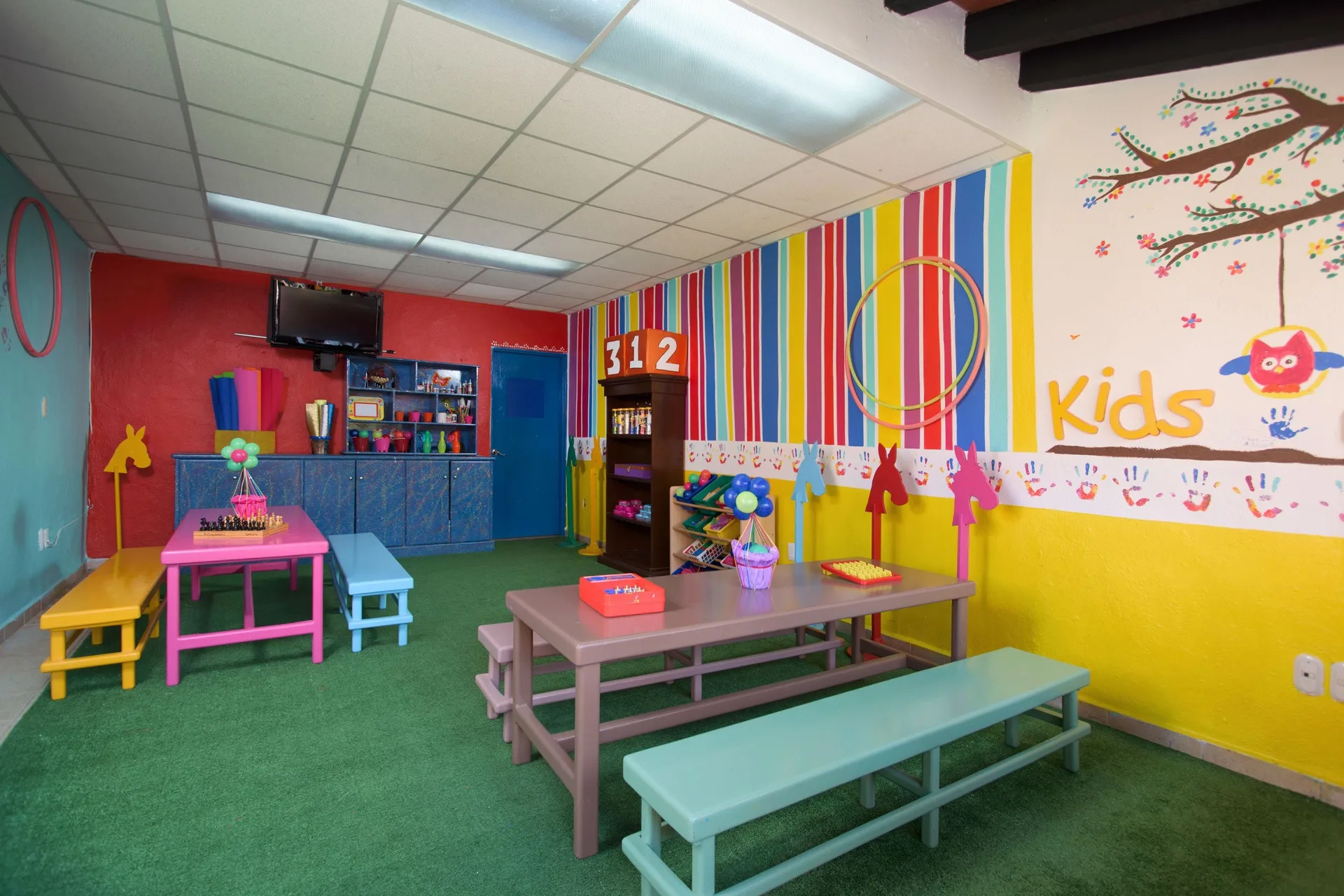 Colorful kids club room with tables and wall art at Villa del Palmar Beach Resort and Spa, Puerto Vallarta.