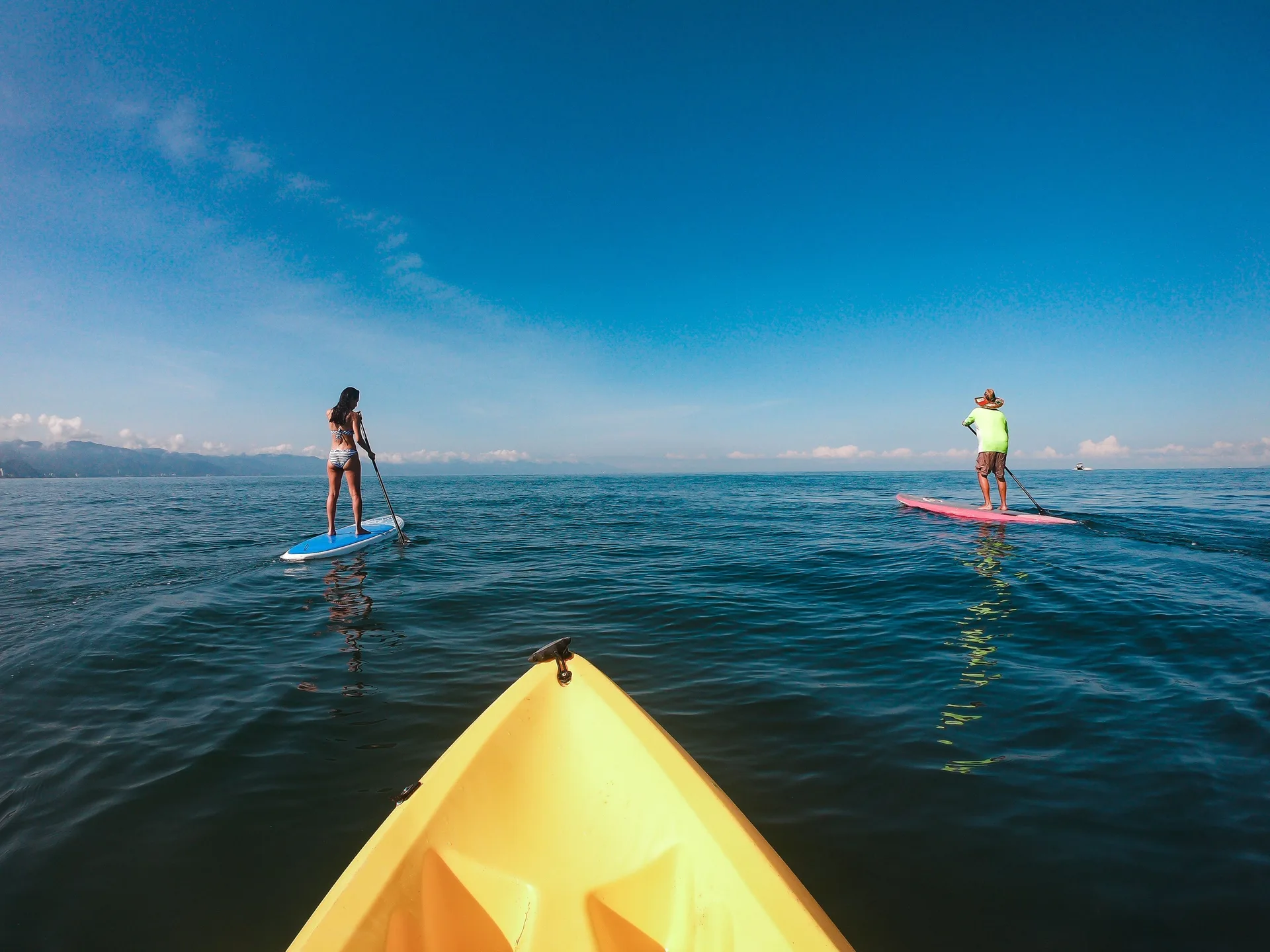 Paddleboarders and the bow of a kayak on the ocean at Villa del Palmar Beach Resort and Spa, Puerto Vallarta.