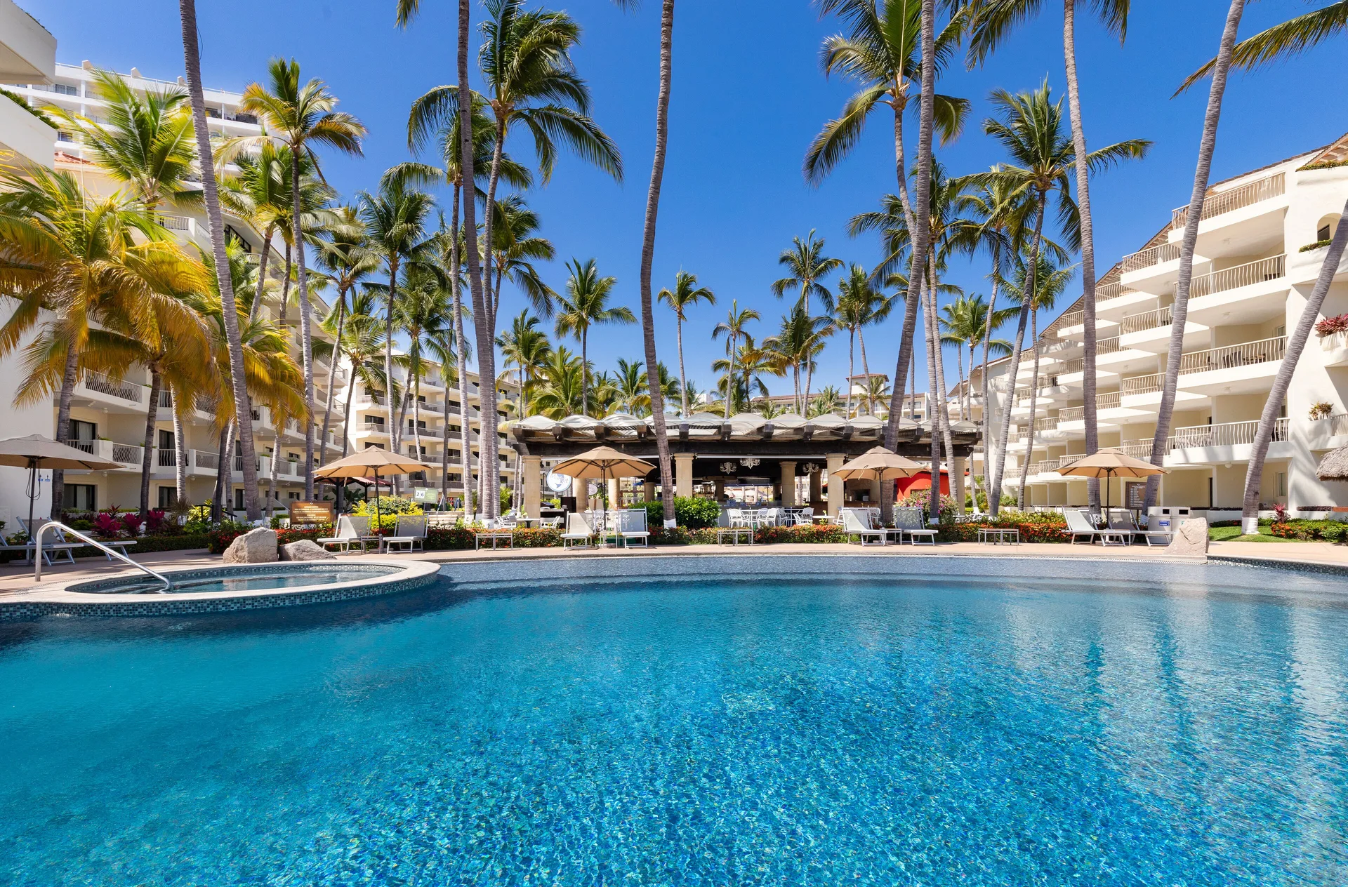 Wide pool view with palms at Villa del Palmar Beach Resort and Spa, Puerto Vallarta.