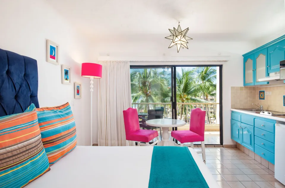 Junior Suite king bed with kitchenette, dining table, and balcony at Villa del Palmar Beach Resort and Spa, Puerto Vallarta.