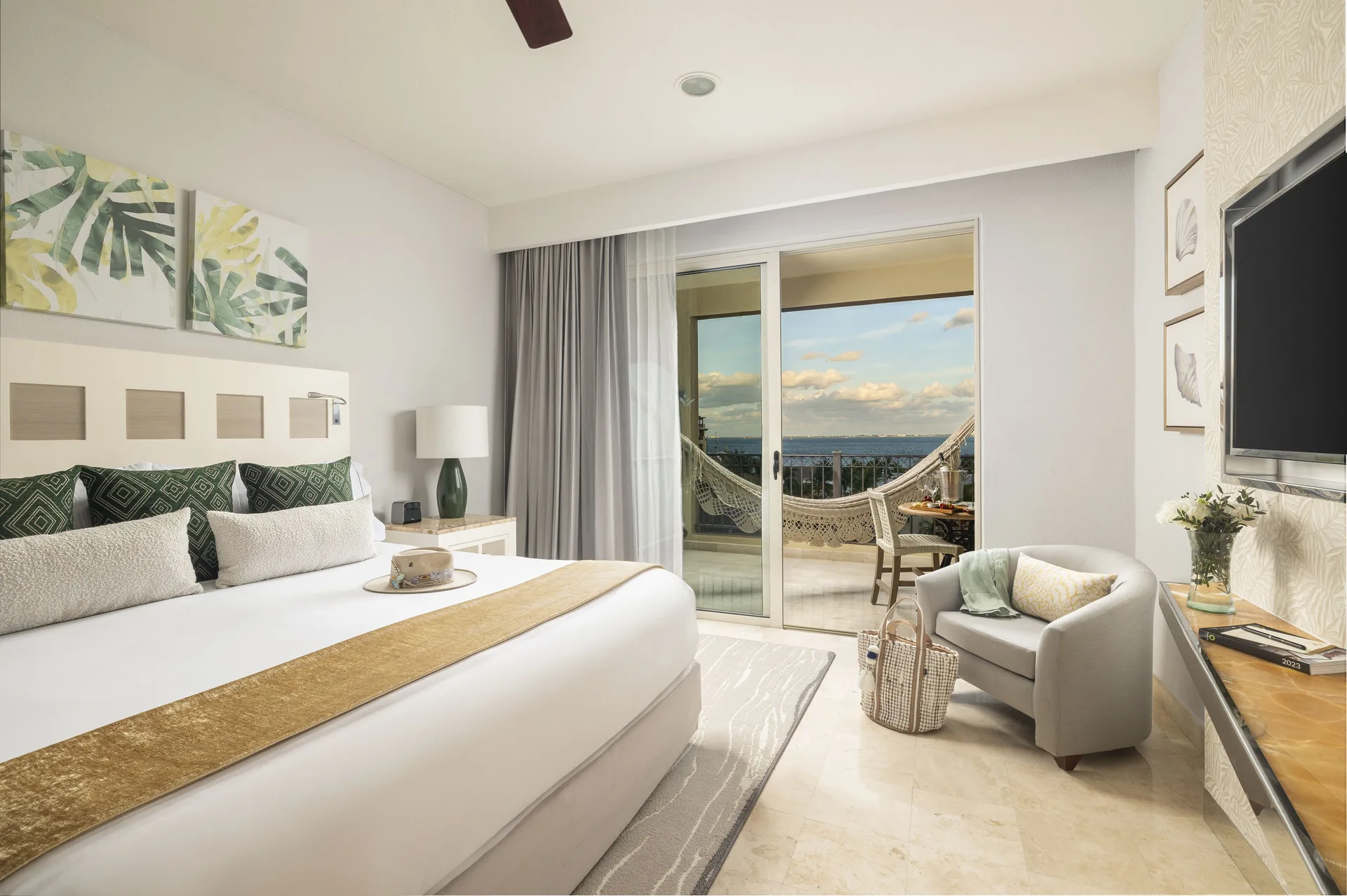Deluxe Ocean View king room with sitting chair and balcony at Villa del Palmar Cancun Beach Resort & Spa.