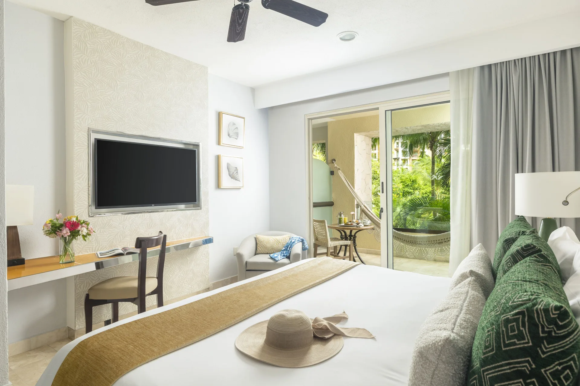 Deluxe room king bed with TV and balcony hammock at Villa del Palmar Cancun Beach Resort & Spa.