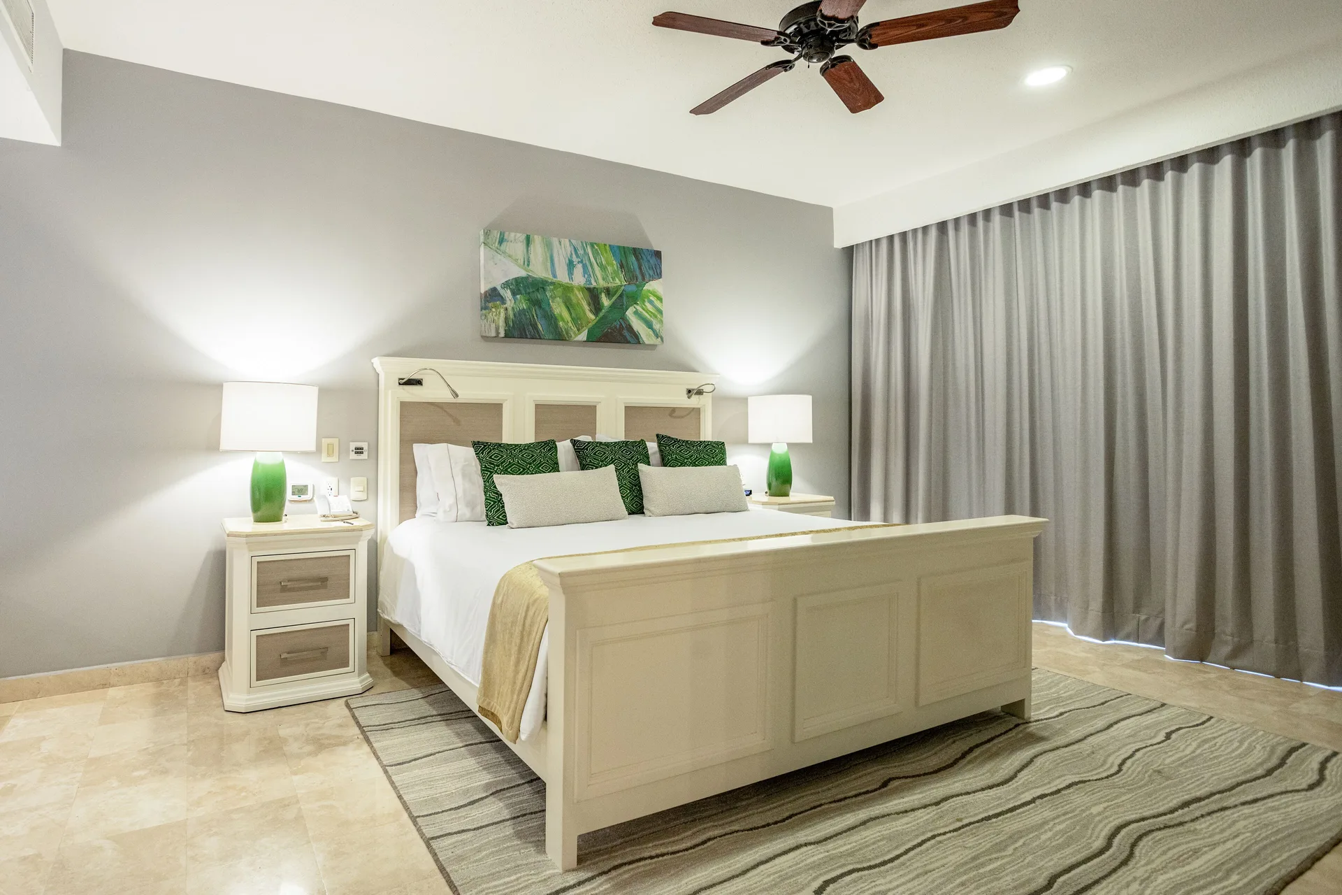 Deluxe room king bed with nightstands and closed drapes at Villa del Palmar Cancun Beach Resort & Spa.