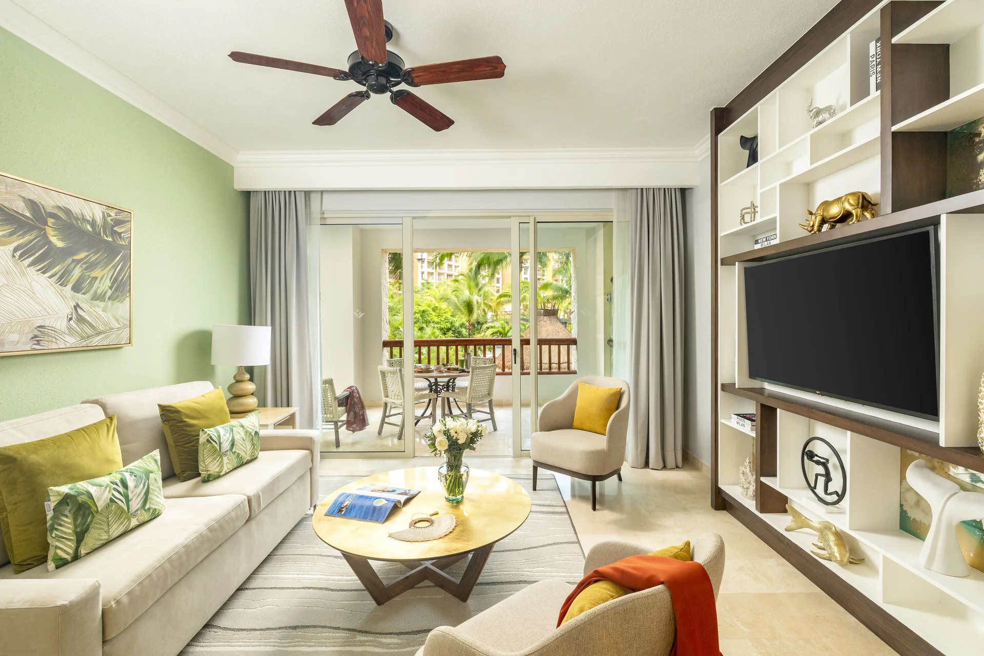 One Bedroom living room with sofa, TV, and balcony at Villa del Palmar Cancun Beach Resort & Spa.