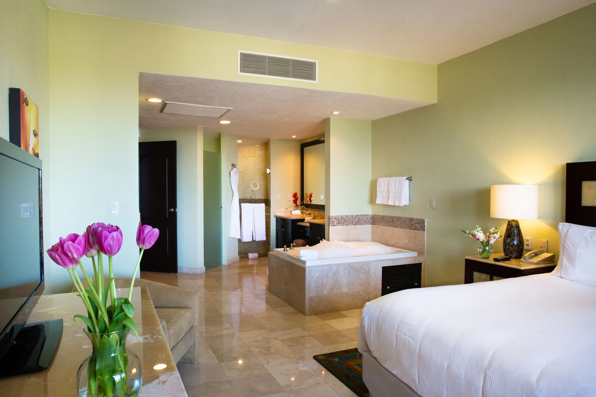 Bedroom with soaking tub and vanity at Villa del Palmar Cancun Beach Resort & Spa.